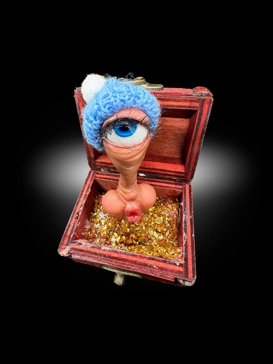 dark humor oddity sculpture about inheritance with eyeball figure in chest