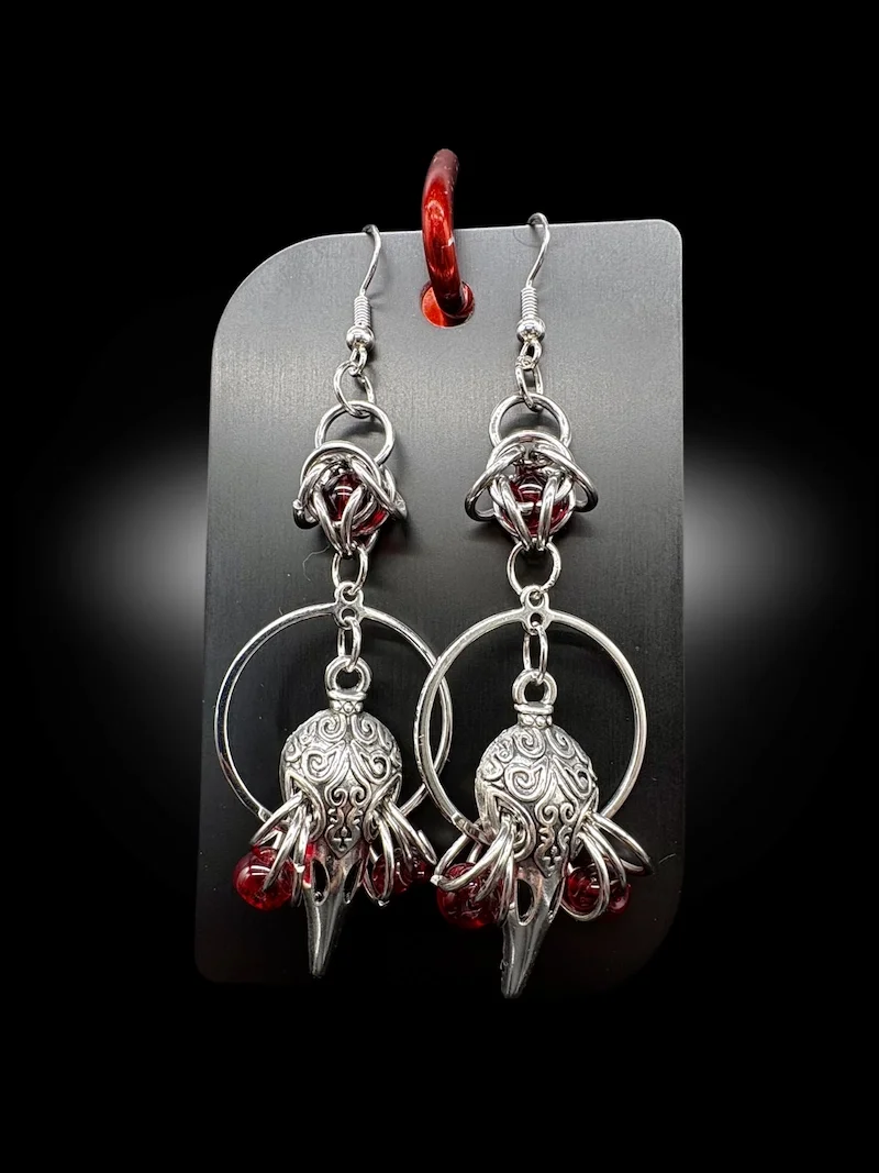 Birds Are Not Real gothic chainmail earrings held in hand showing size and detail