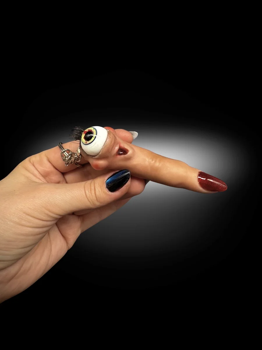 Eyeball finger keychain attached to keys showing scale and use