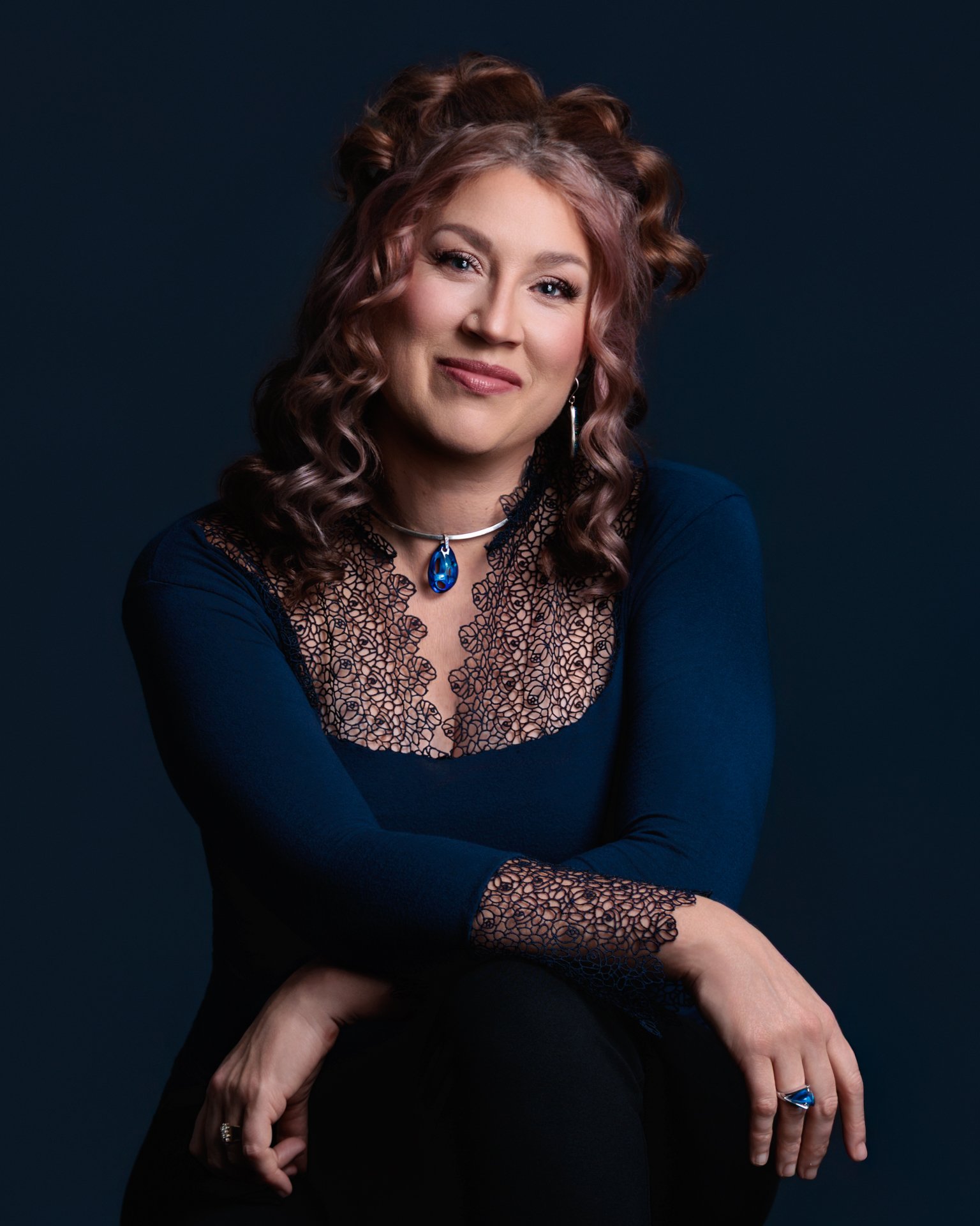 Professional headshot of an accomplished female musician, pianist, choir director, and vocal coach, photographed in a clean studio setting. Confident and approachable expression with polished professional attire, ideal for branding, website profiles.