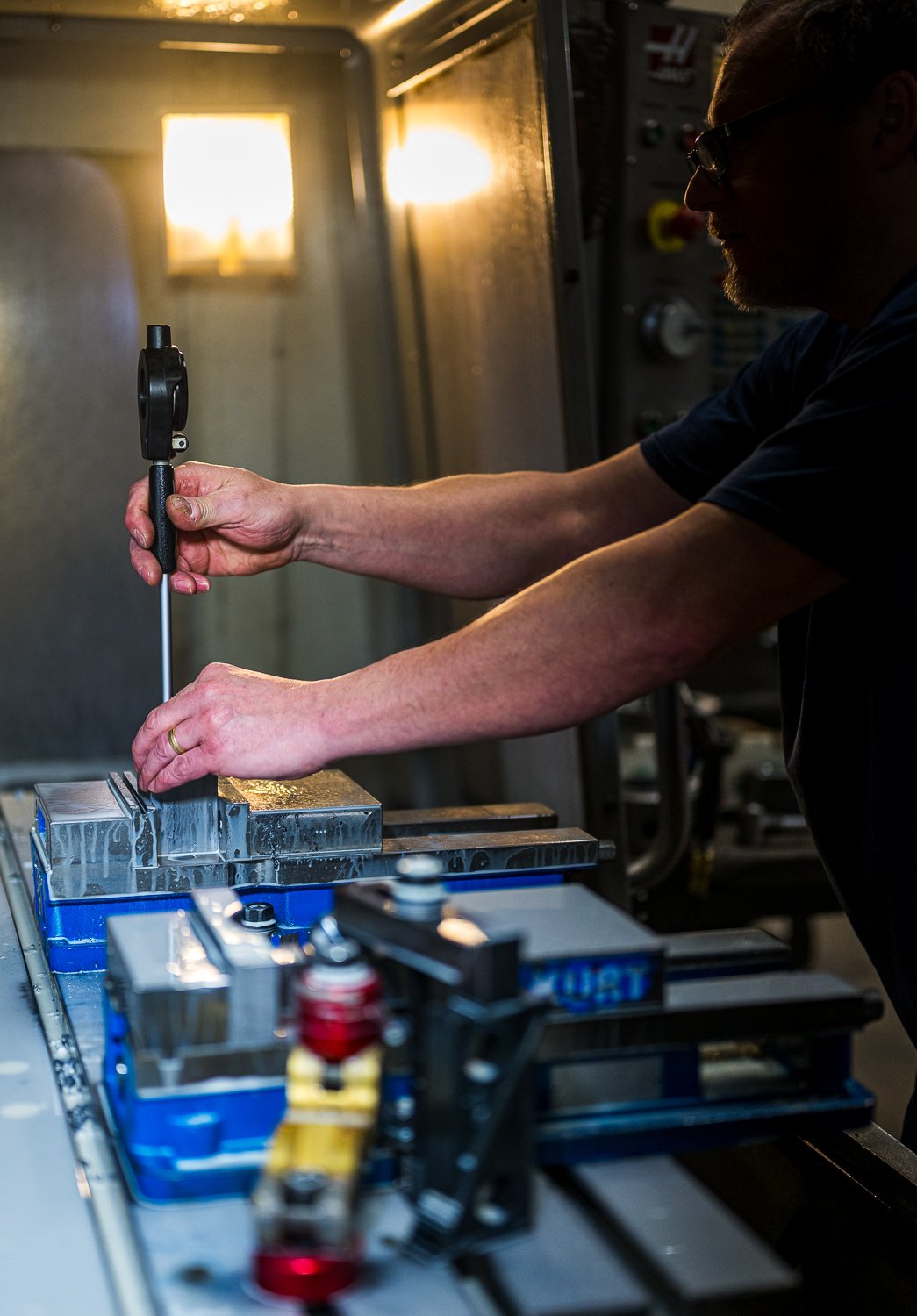 A person precision measuring a part in a milling machine.