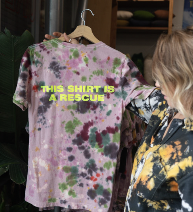 woman holding up a tie dyed t-shirt
