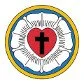 Emblem featuring a cross inside a heart, surrounded by a circular band with text and decorative elements.