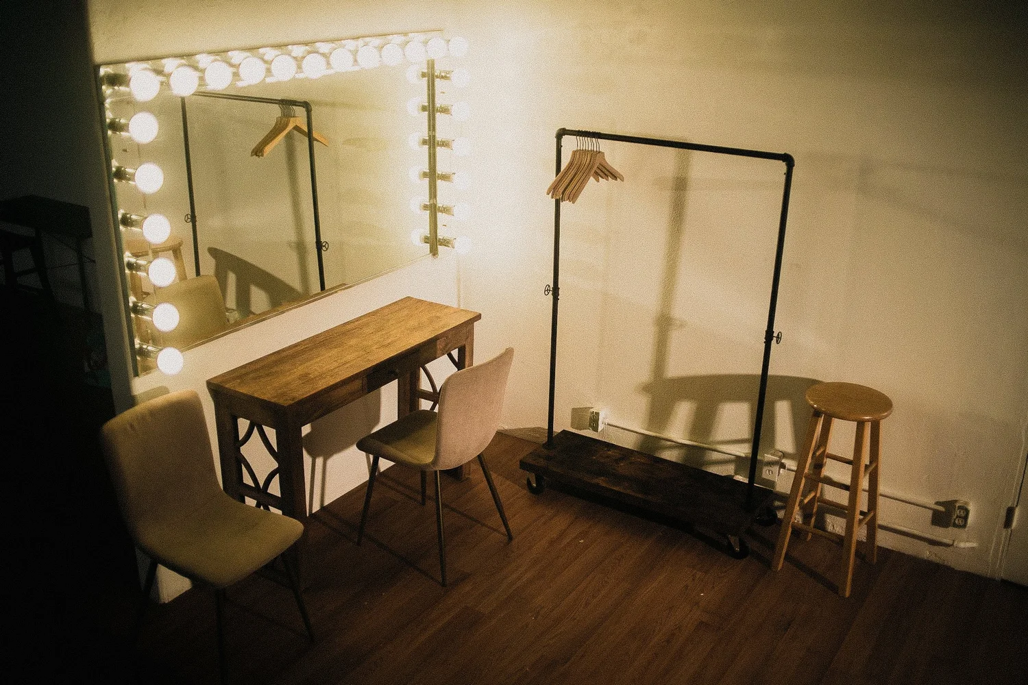 Illuminated vanity mirror with seating and clothing rack