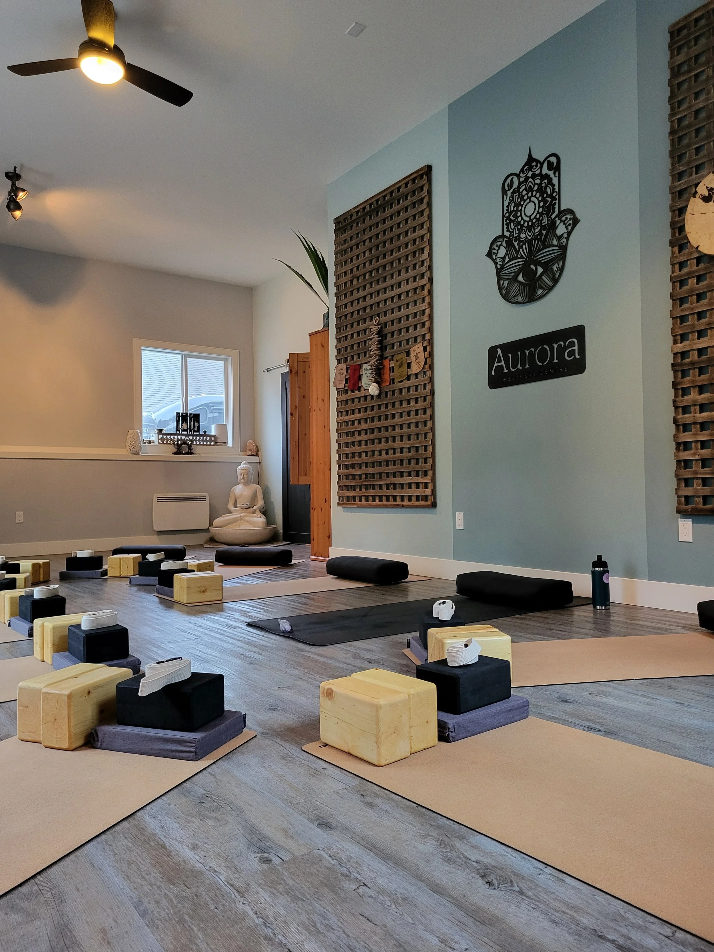 Person practicing yoga on a mat using yoga blocks for support.