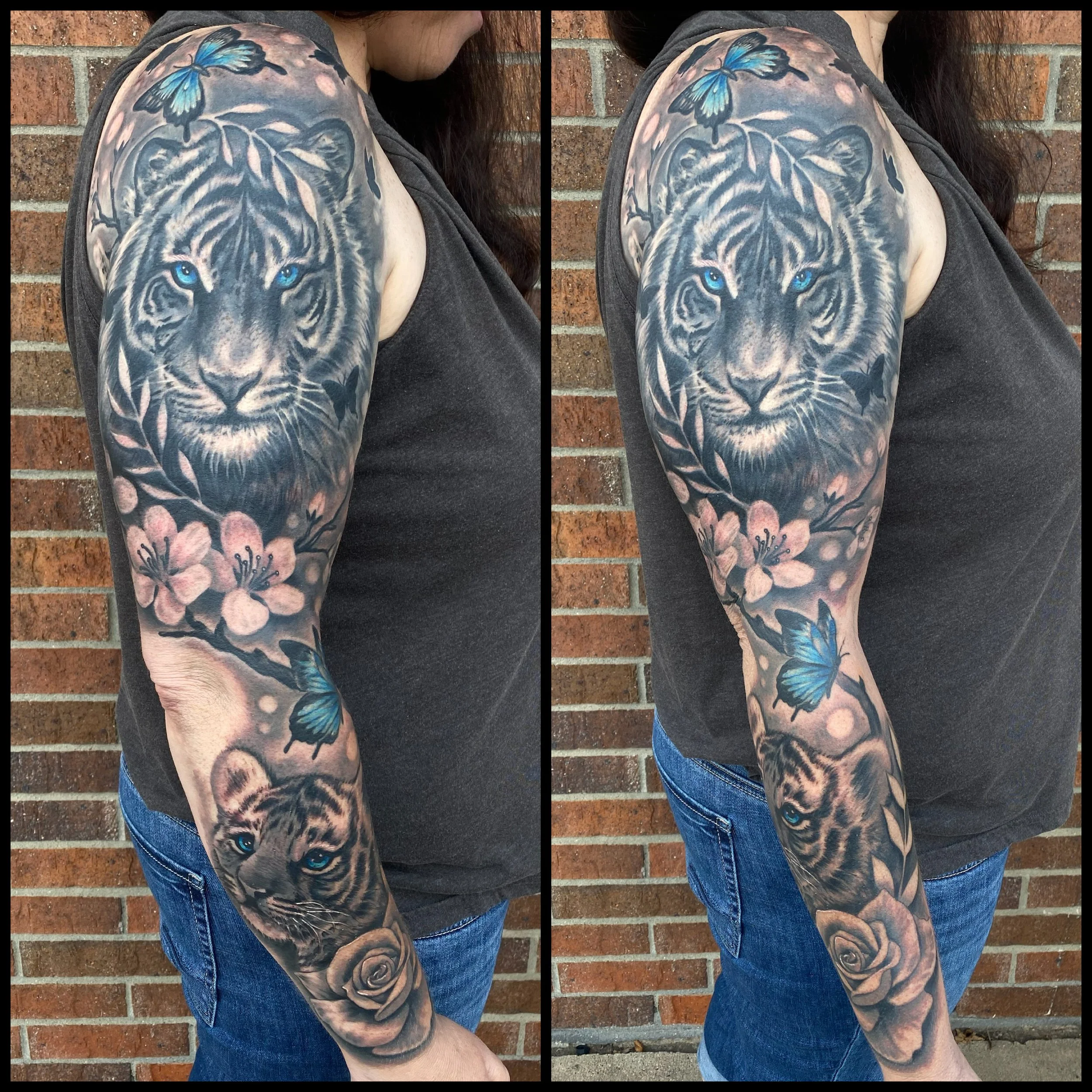 Tattoo of a tiger with blue eyes, surrounded by cherry blossoms, butterflies, and a rose on a person's arm.