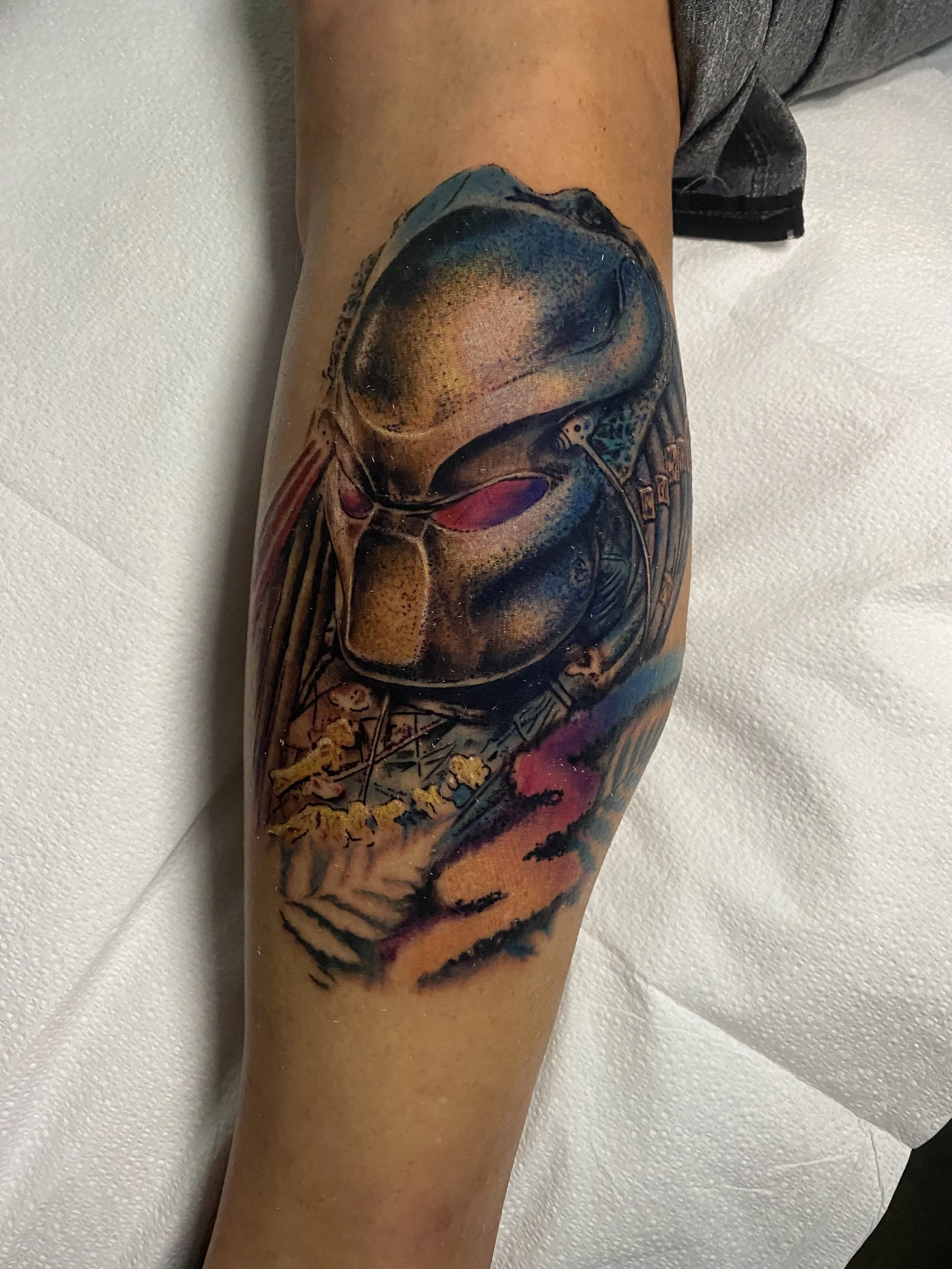 Tattoo of an astronaut helmet and space scene on a person's leg