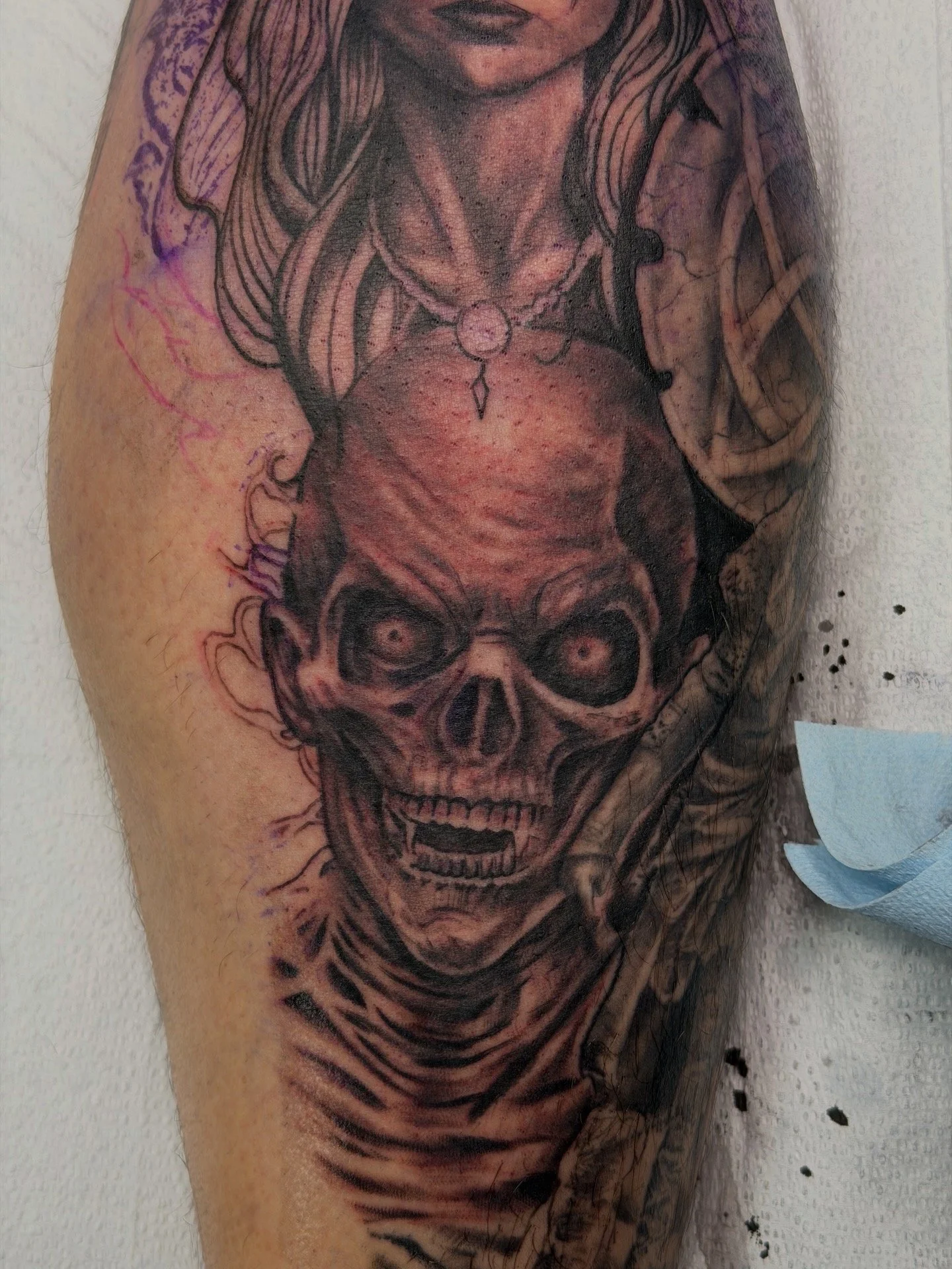 Sioux Falls South Dakota Tattoo Shop. Apex Ink. Tattoo of a human skull with hollow eye sockets and an open mouth on an arm.