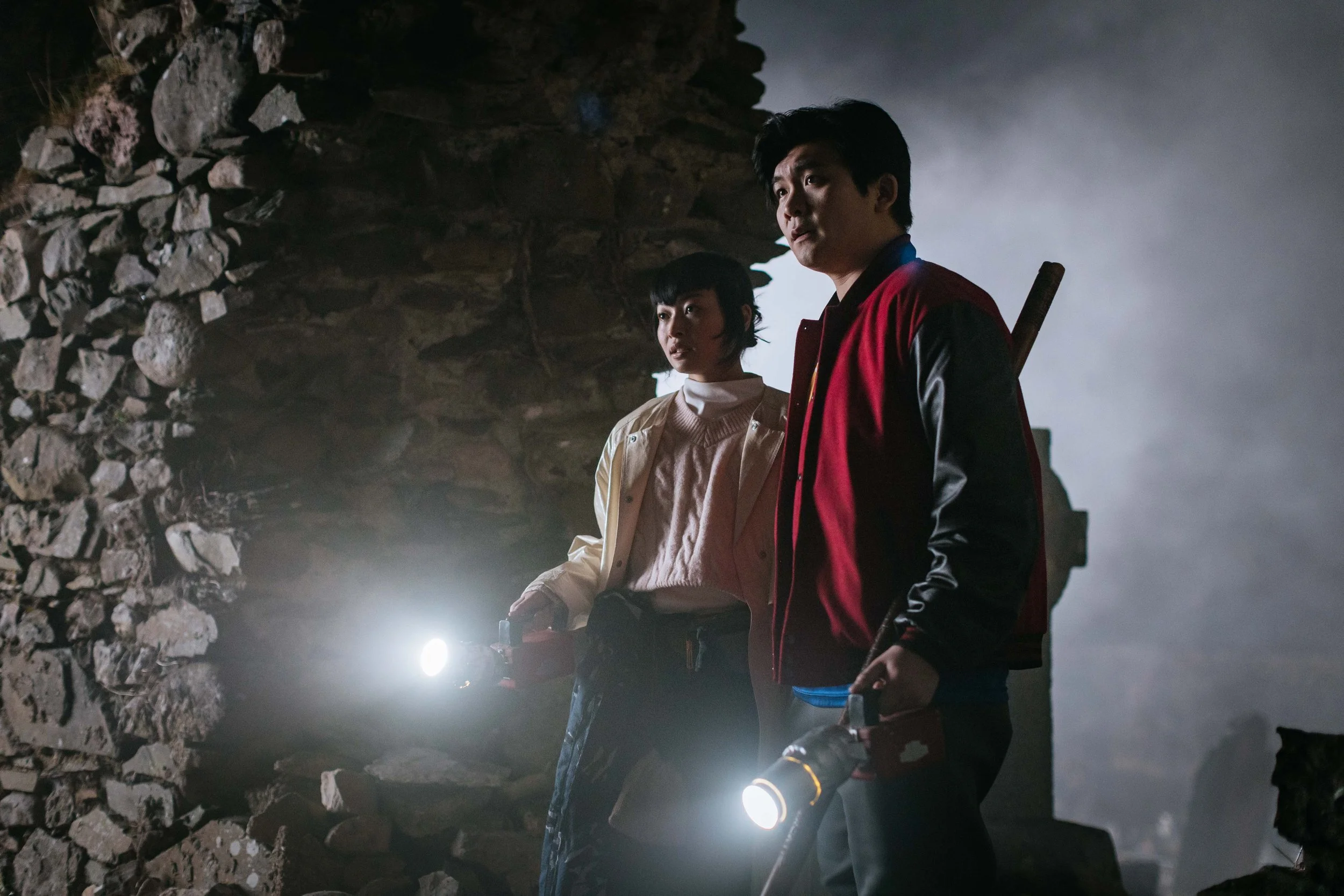 Man and woman in cave with flashlights