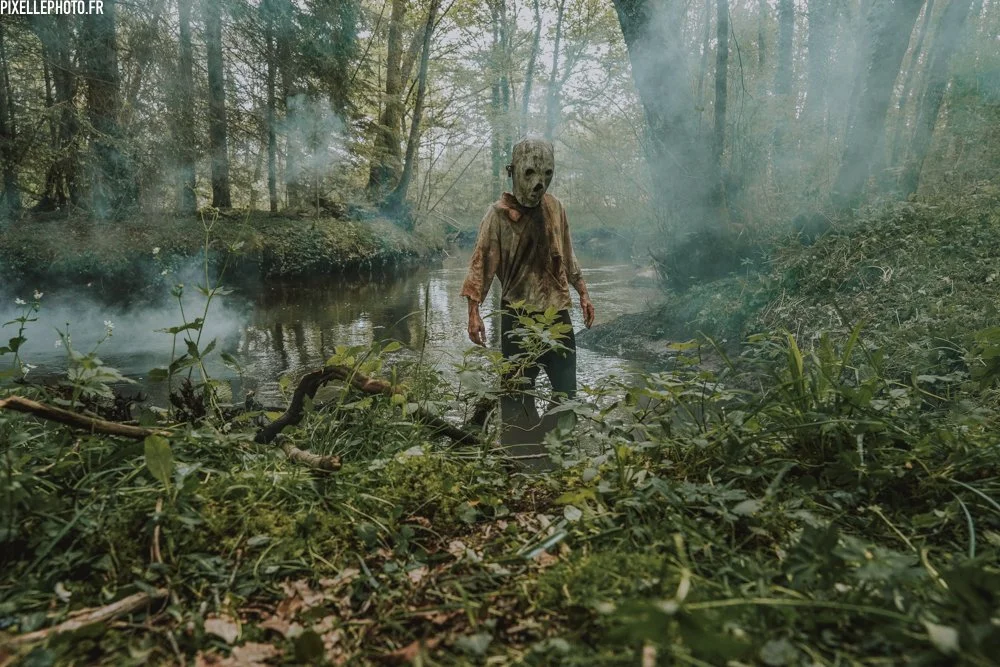 Child in a blank wooden mask in a swamp
