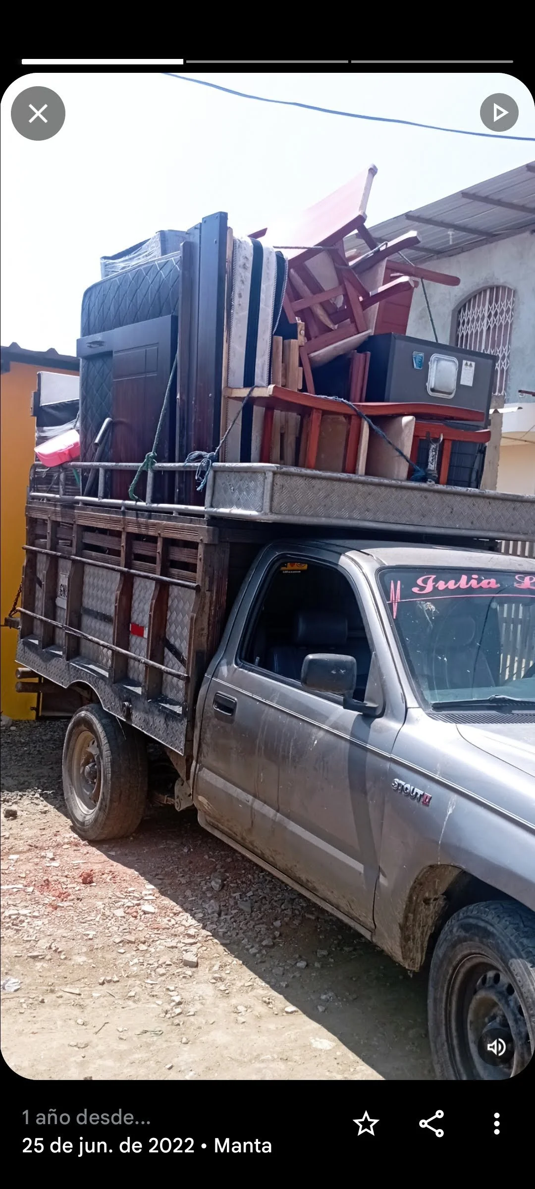 Camioneta cargada con muebles y cajas en un terreno de tierra en Manta, Ecuador.
