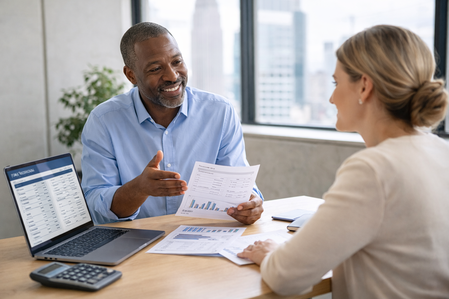 Payroll consultant meeting with a small business owner to review payroll documents in a modern office