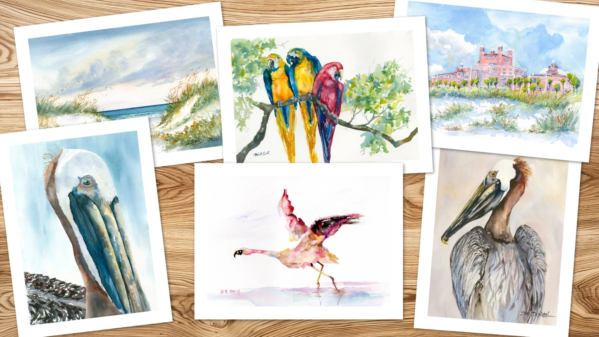 Collection of six watercolor paintings of birds and landscapes spread on a wooden surface.