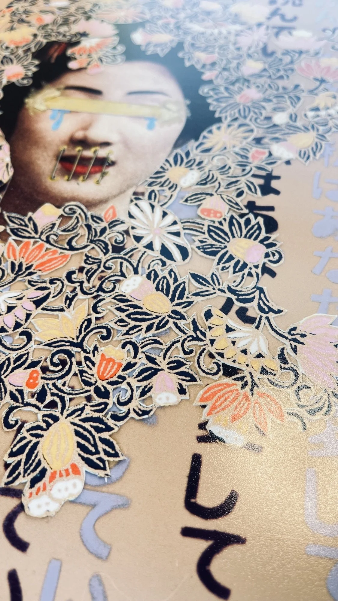 Close-up of a fine art print on premium luster paper. The artwork features a woman's / geisha's face with traditional Japanese-style makeup, surrounded by intricate floral designs and cutouts.