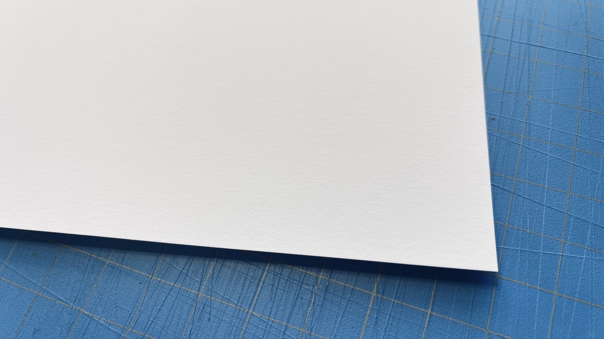 Close-up photo depicting the subtle texture of our white, natural cotton rag paper. Red River Aurora Art White 250 gsm