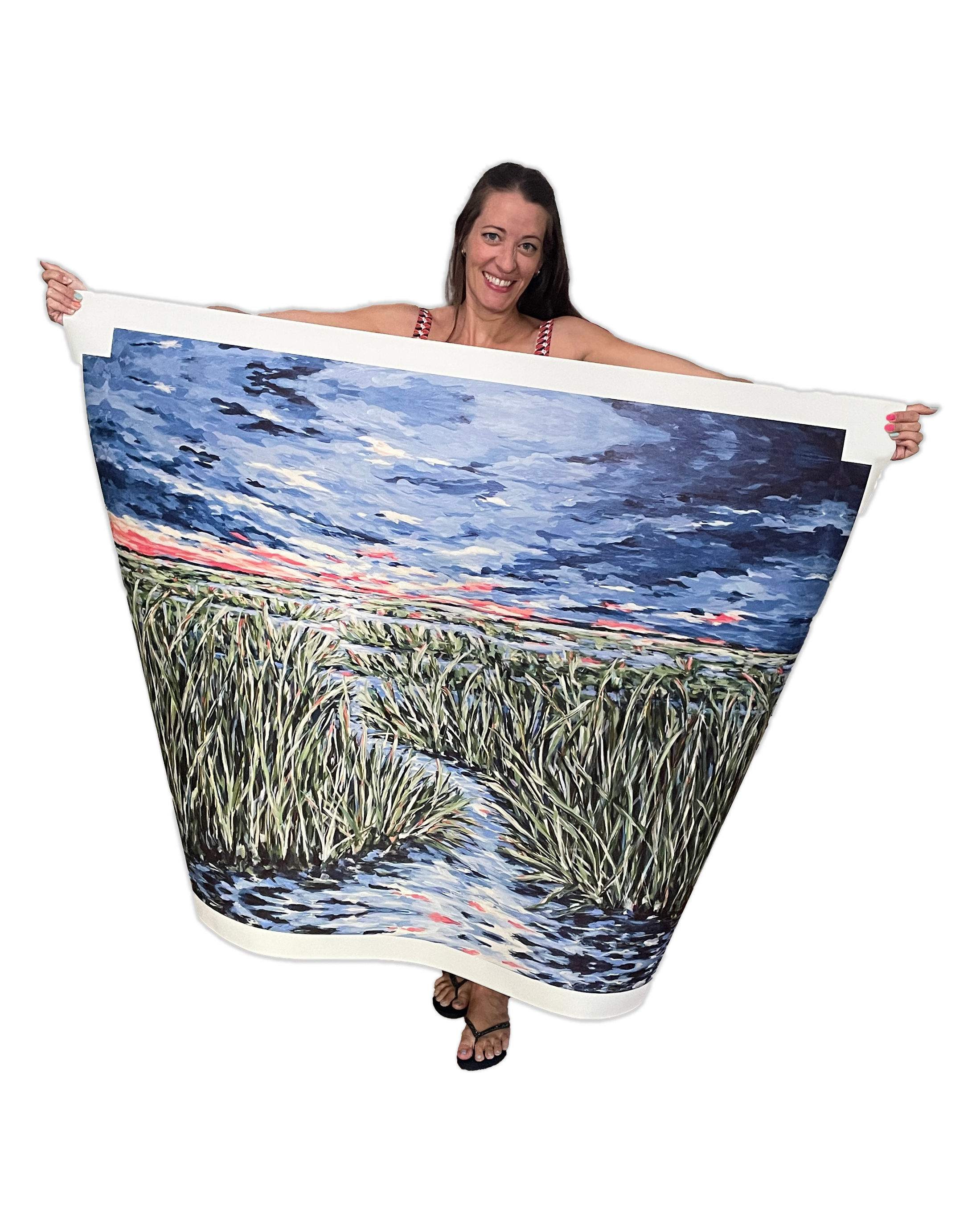 Rosemary holding a large format canvas print of a landscape painting featuring a big sky, sunset, and a winding waterway through tall grass.