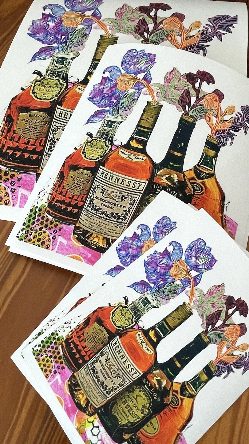 Three different sizes of the same fine art prints on Somerset velvet paper. Colorful prints of bottles of Hennessy cognac with flowers in the bottles, placed on a wooden surface.