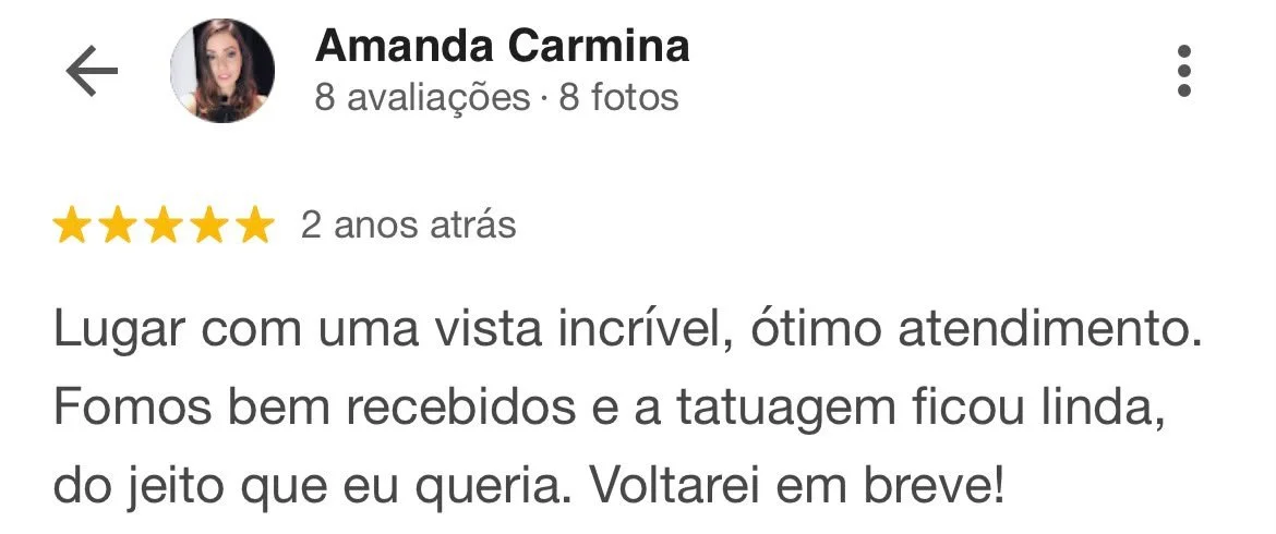 Avaliação de cliente com cinco estrelas, escrita em português, elogiando um local com vista incrível, ótimo atendimento, bom recebimento, uma tatuagem feita e prometendo retornar em breve.