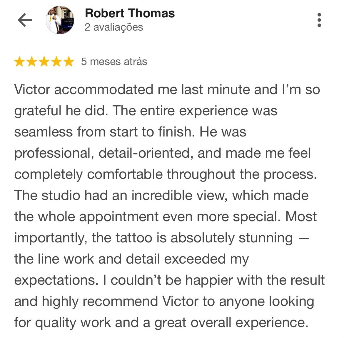 Avaliação de cliente com cinco estrelas, descrevendo a experiência positiva com um profissional chamado Victor em um estúdio com vista incrível, destacando um tatuagem detalhada.