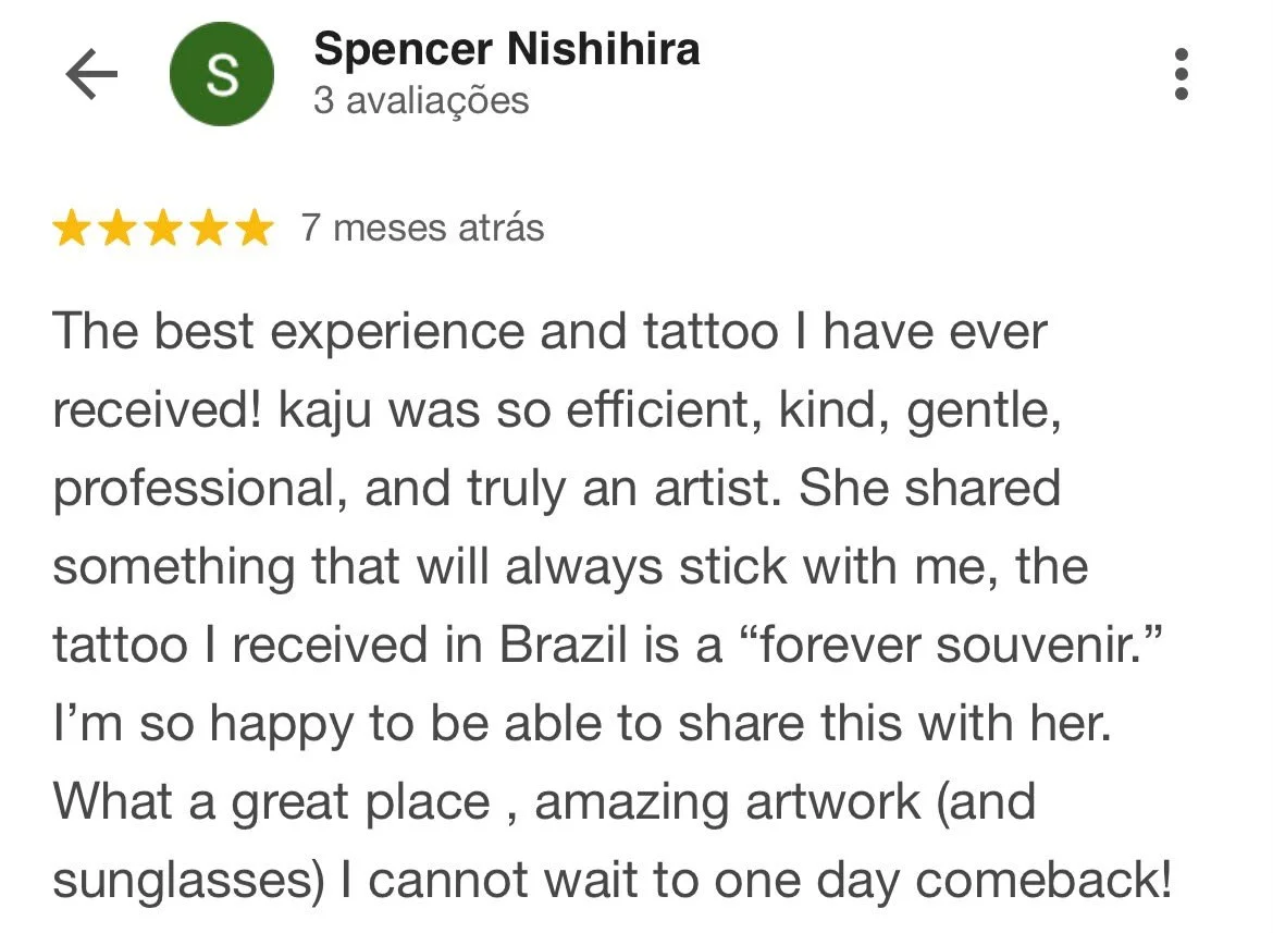 Avaliação de cliente com estrelas douradas, nome Spencer Nishihira, comentários positivos sobre um tatuador chamado Kaju, destacando eficiência, gentileza, profissionalismo e talento, mencionando uma tatuagem feita no Brasil como lembrança eterna.