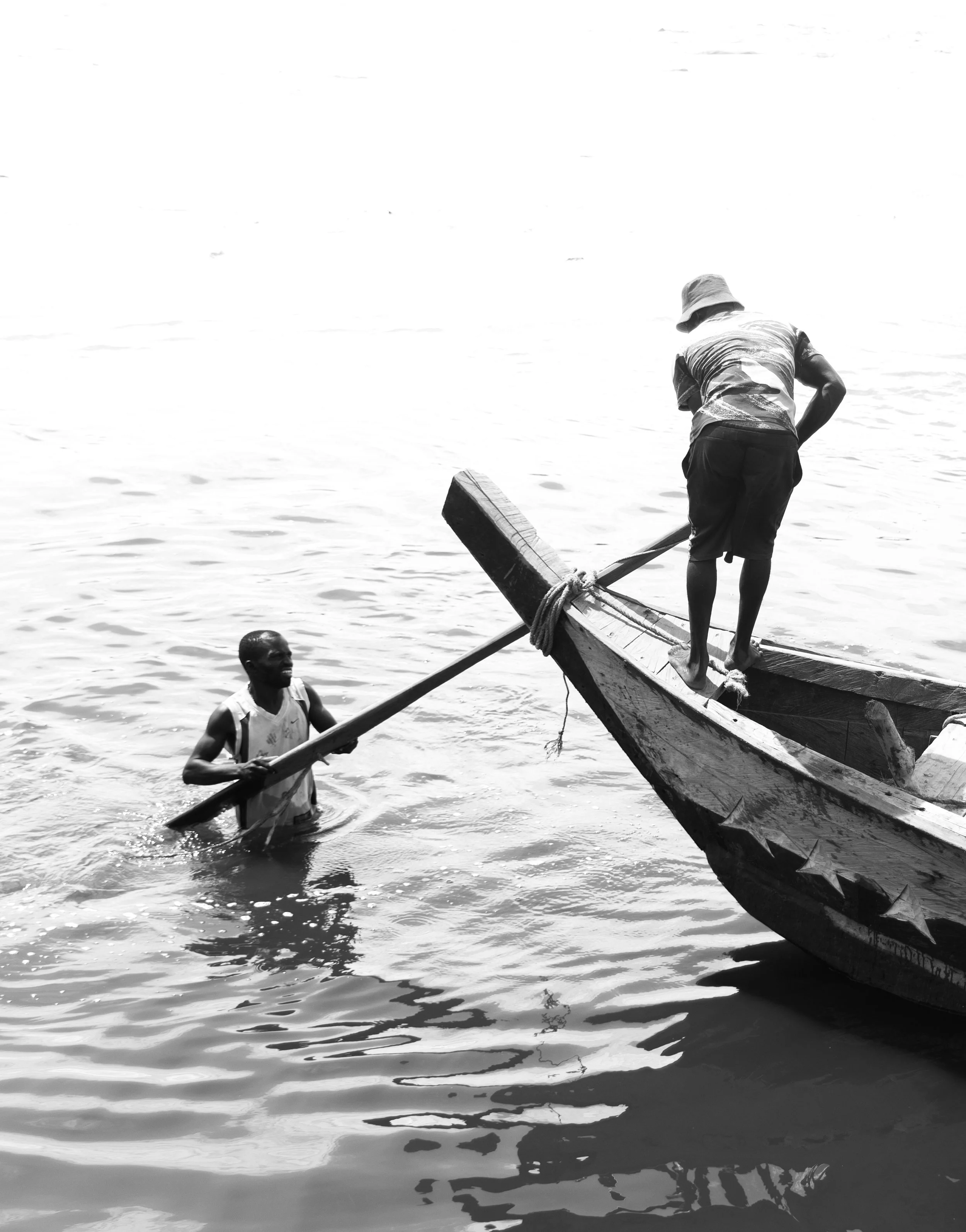 Two men working on a boat in the Teshie port.
