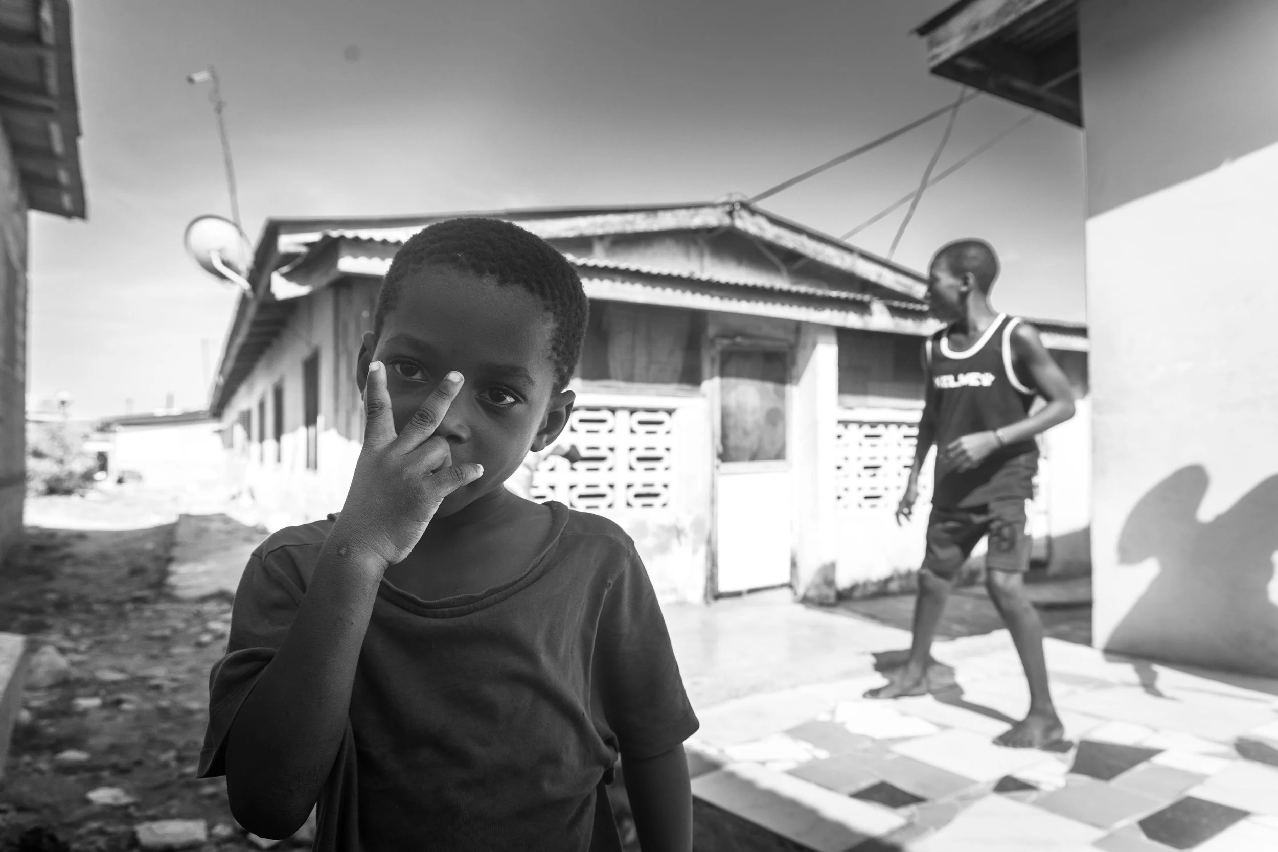Three boys playing soccer in the alleyways of Teshie, Ghana.