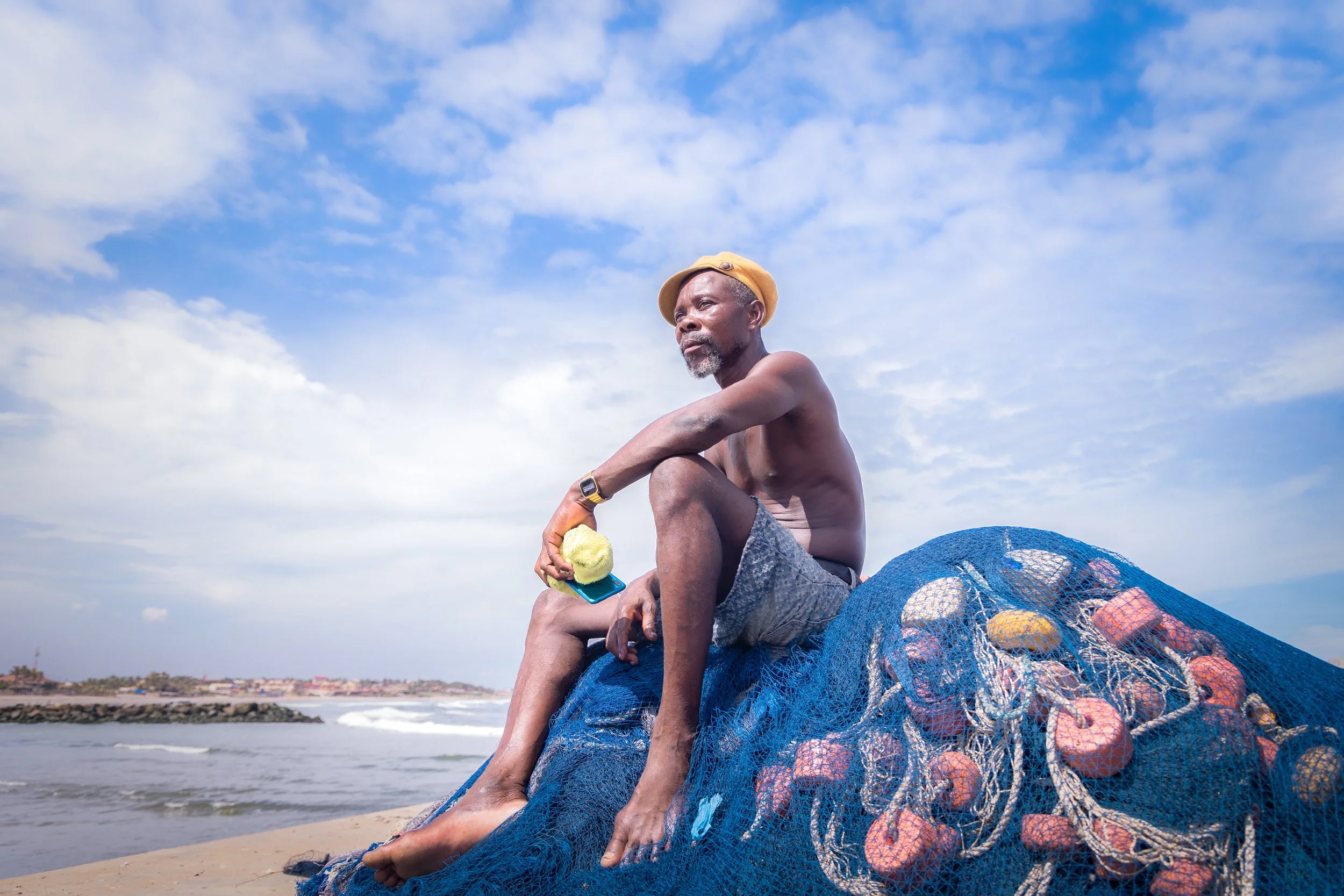 An elderly man resting on the pier at Teshie fishing port.
