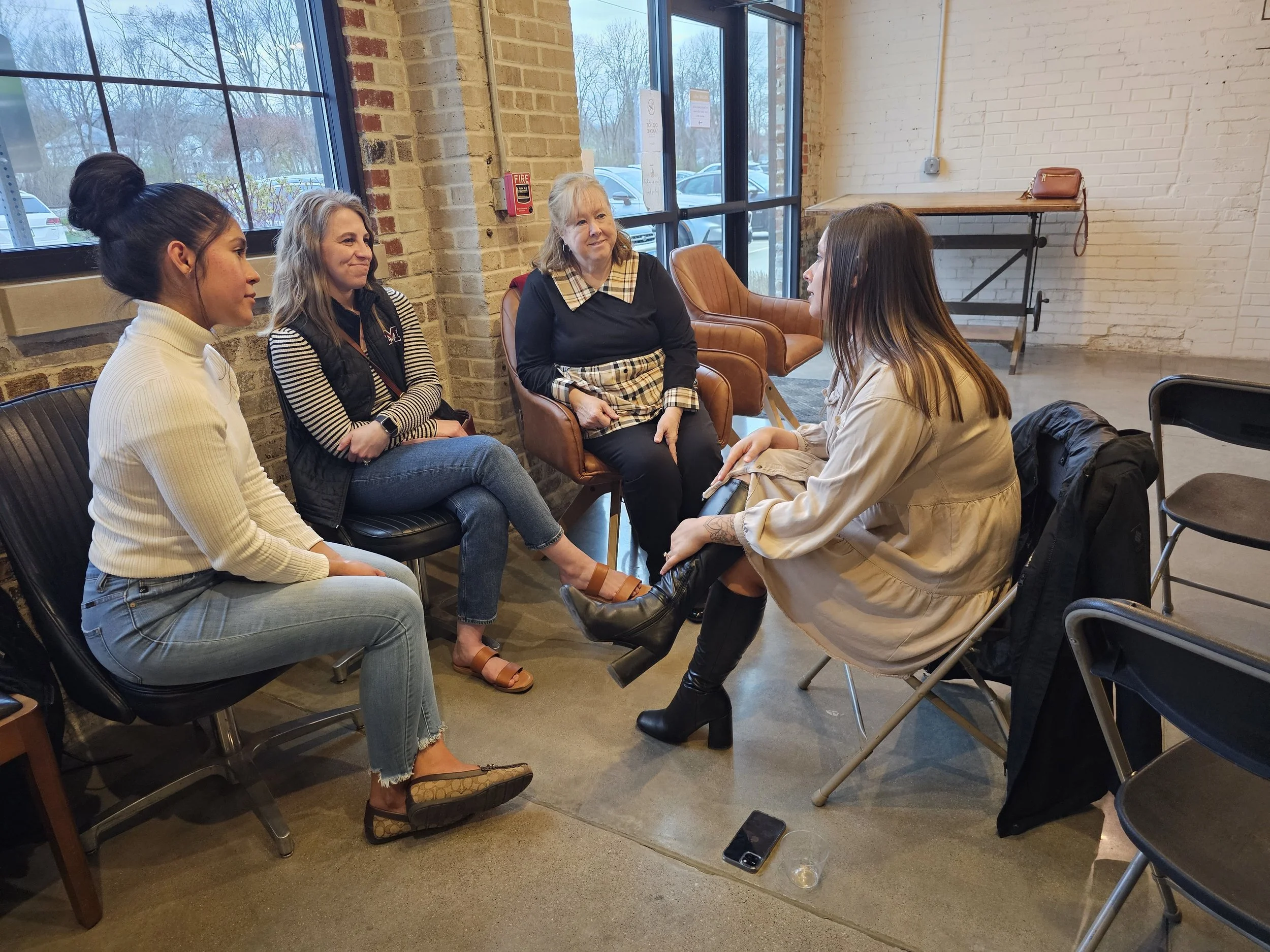 Photo of Lead(H)er QC team collaborating around a table, representing leadership and collaboration.