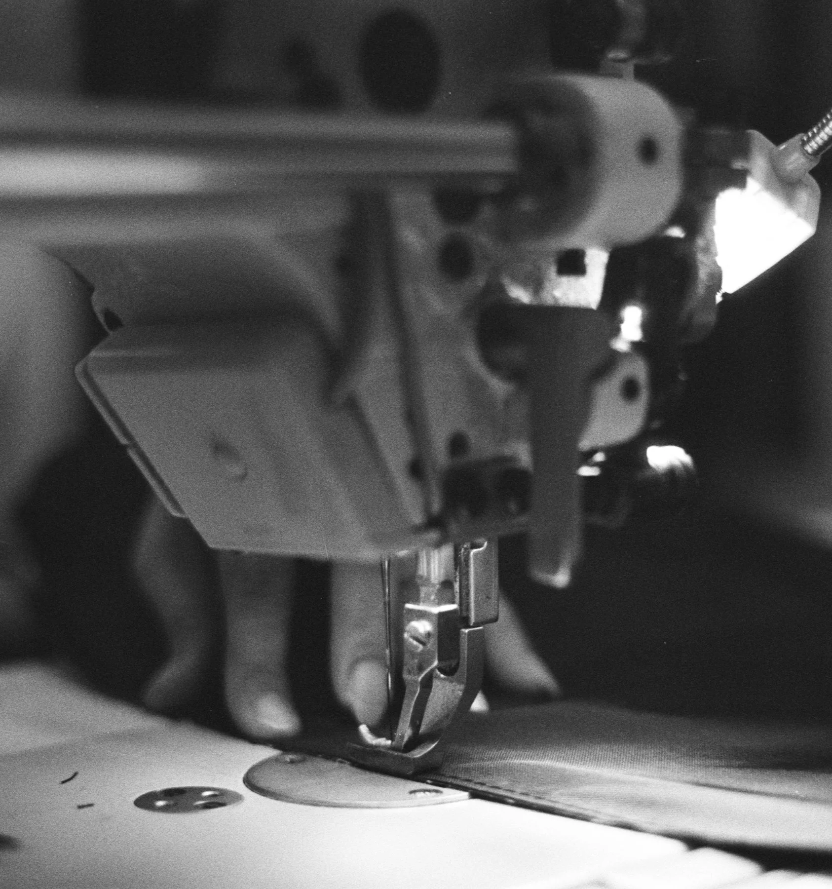 Close-up of a sewing machine needle stitching fabric.