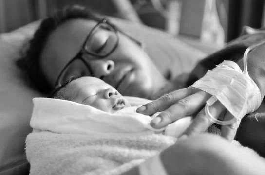 black and white photo of a woman and her newborn baby