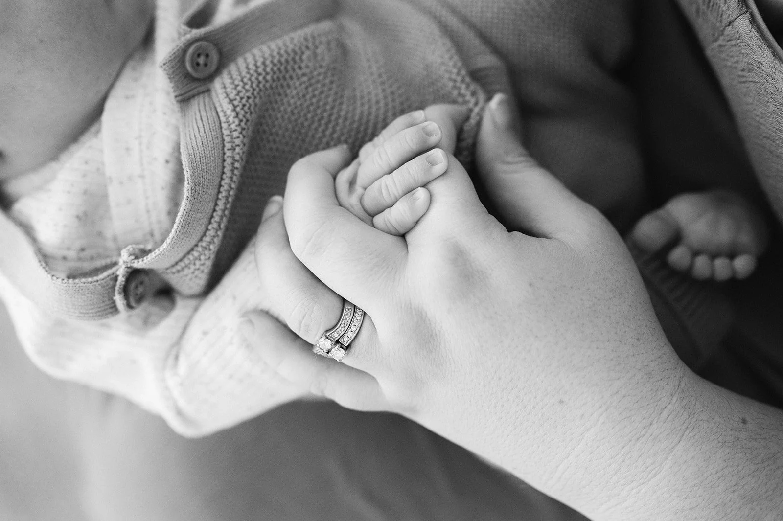 Close-up of a Rachael Bardnell holding a baby's hand.