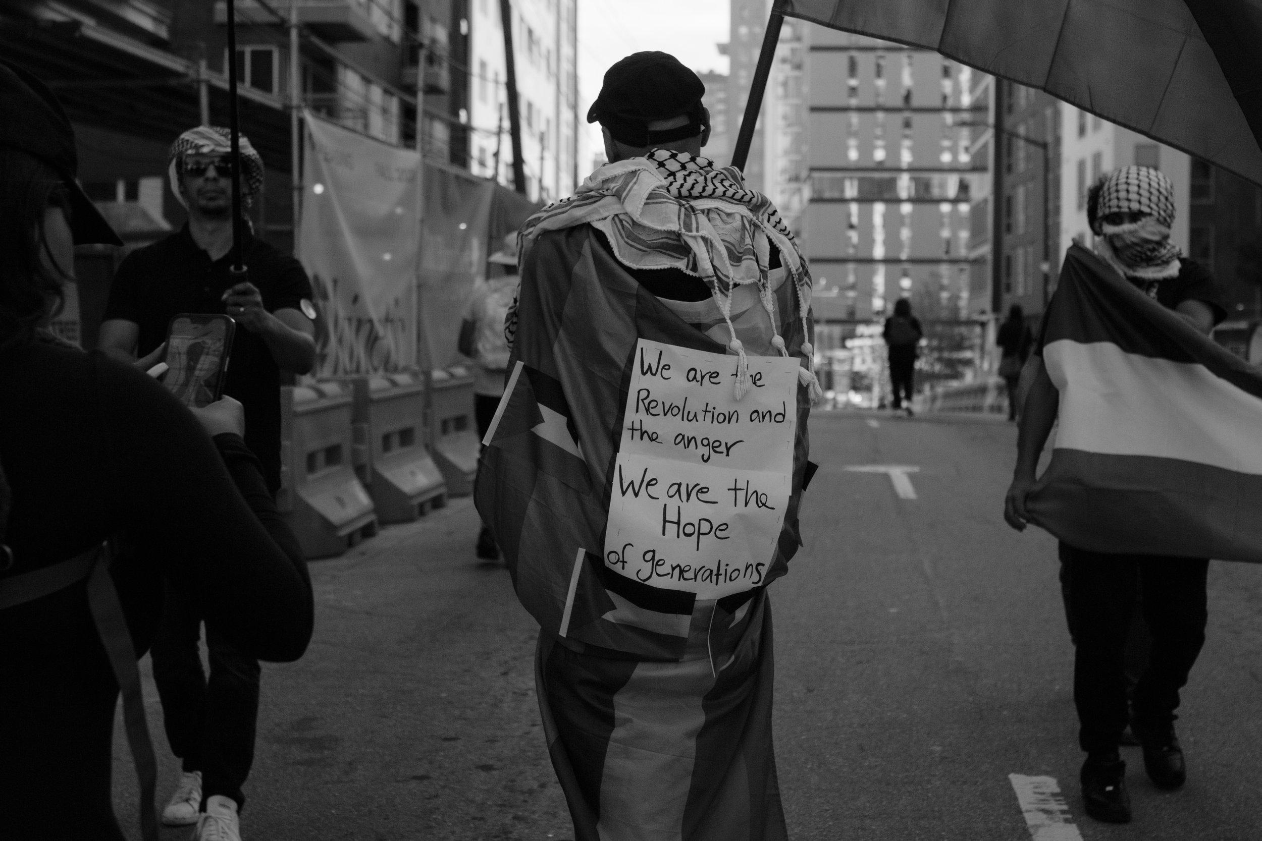 October 22, 2023 | A protester wears a sign that reads, “We are the Revolution and the anger. We are the Hope of generations,” during a protest in Atlanta, Georgia, outside the Consulate General of Israel. The march, organized by The Atlanta branch o
