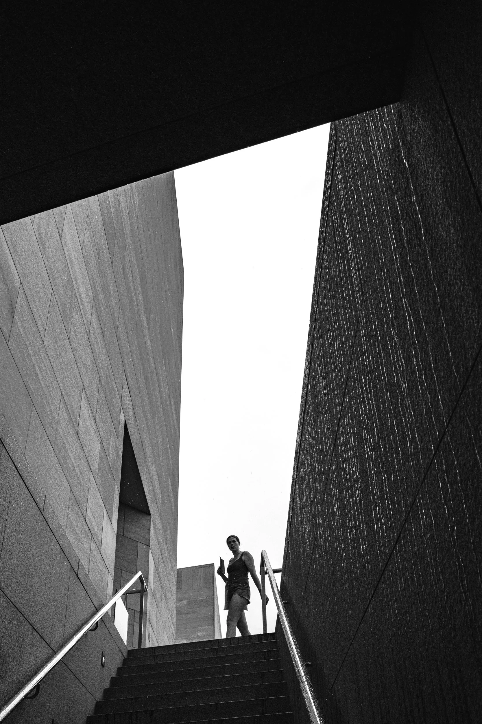 Silhouette framed by sharp angles at the National Gallery of Art, Washington DC. Black and white art photography.
