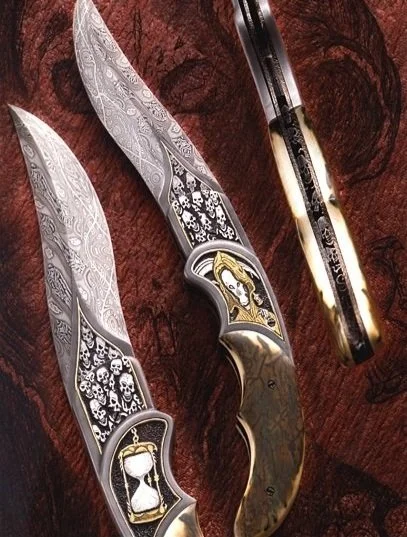 ~Your Time Is Up~
Is a step-down folder. It has 24k gold and fine silver inlay and the length of the blade, including the step-down, is 4 ¾ inches, and the knife overall is 8 ¾ inches. The handle is ancient mammoth ivory. The theme of this knife was