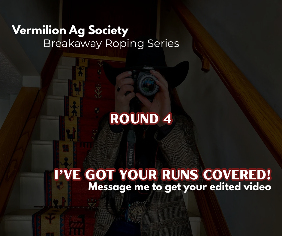 A person dressed in a brown checkered blazer, holding a Canon camera, standing on a staircase with a colorful rug, wearing a black cowboy hat, taking a photo.