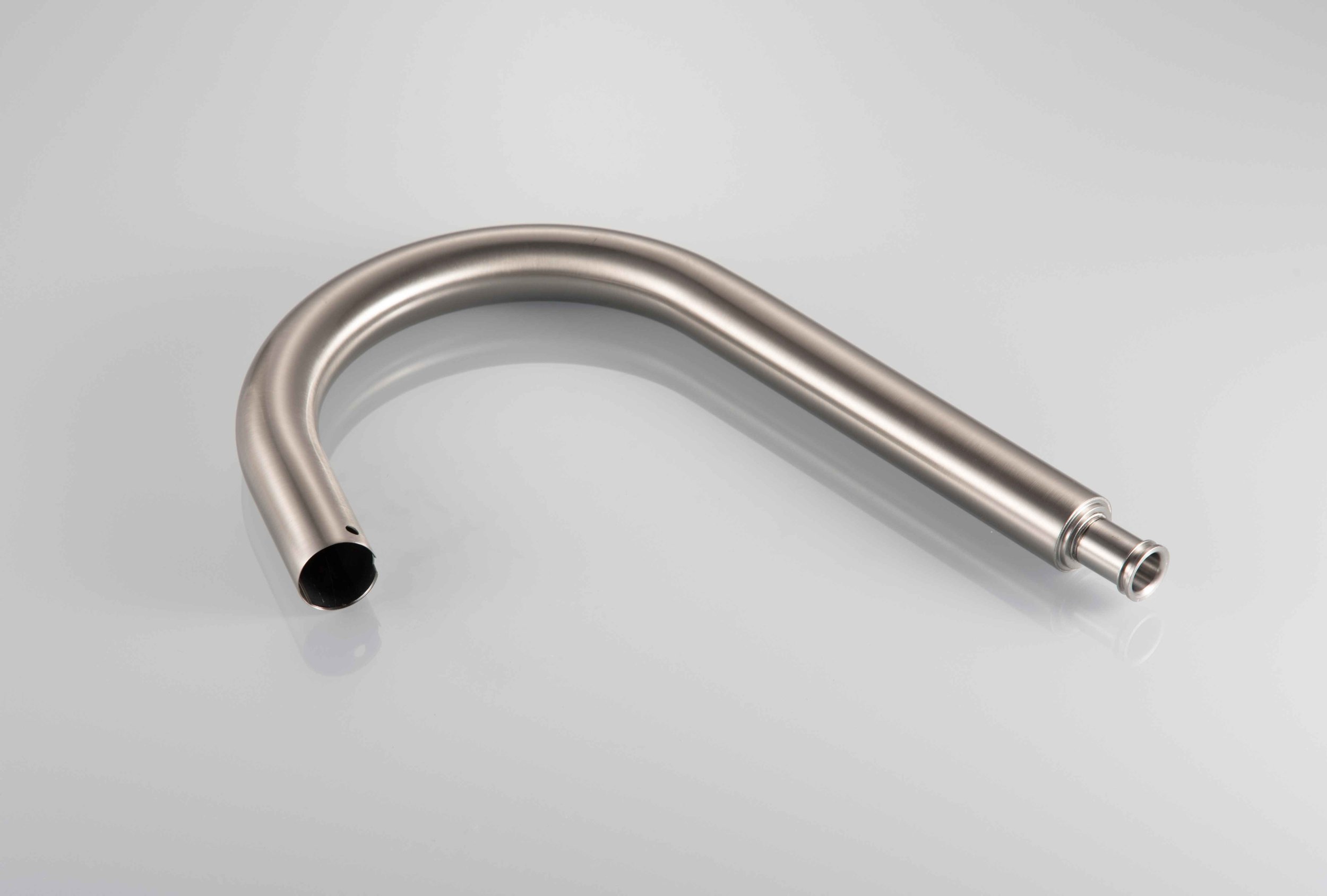 Stainless steel exhaust pipe bending at a 90-degree angle with open ends on a plain white surface.