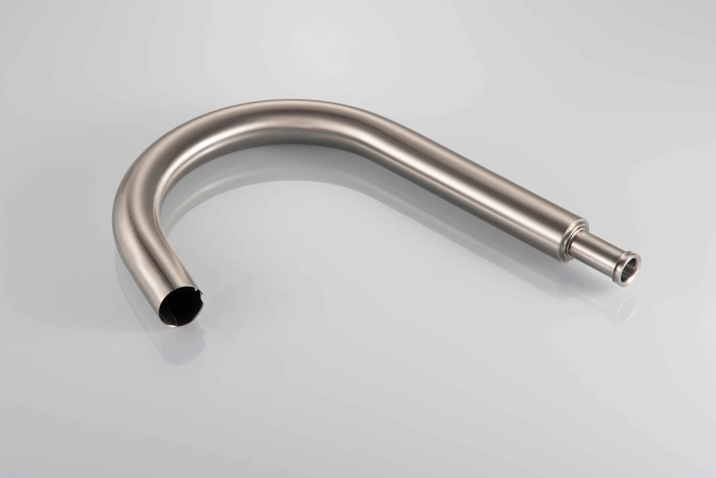 Stainless steel U-shaped pipe with open ends, lying on a white surface.