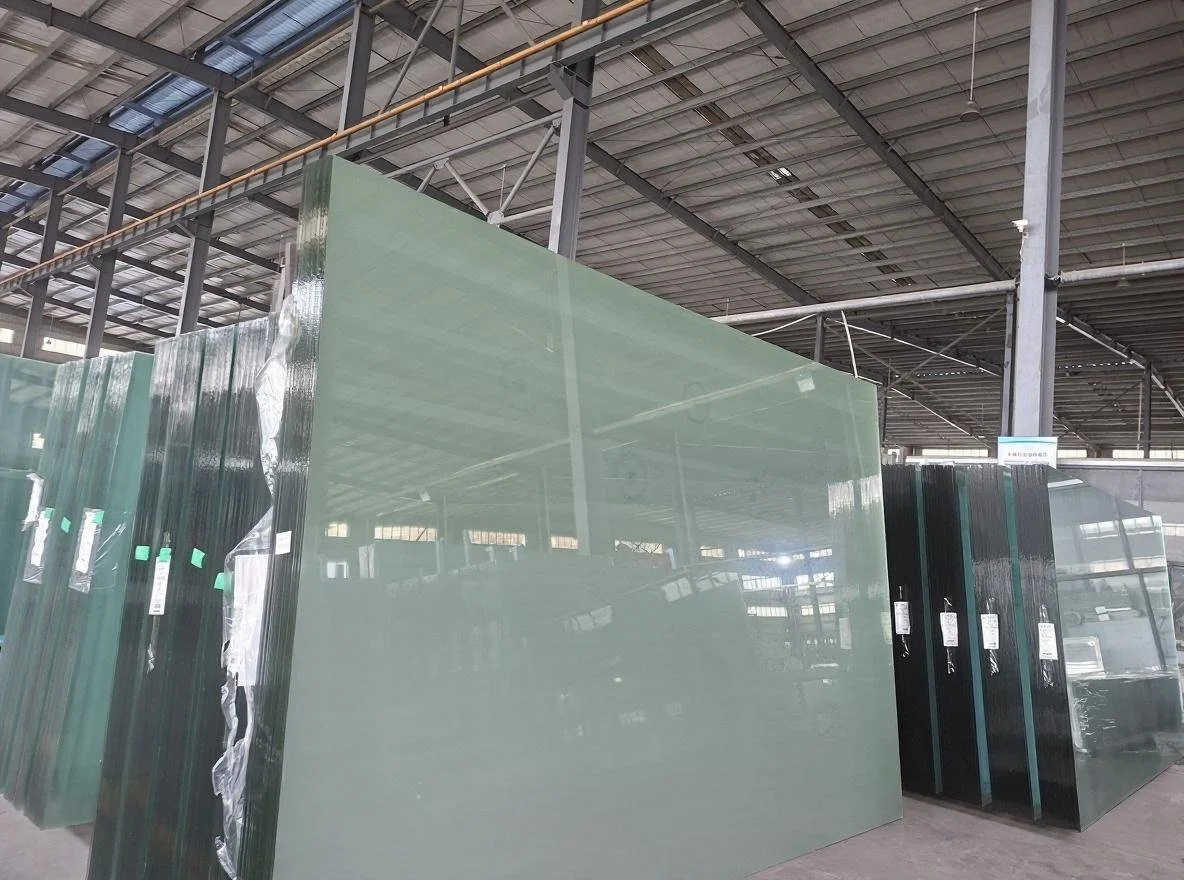 Stacks of large glass sheets in an industrial warehouse.