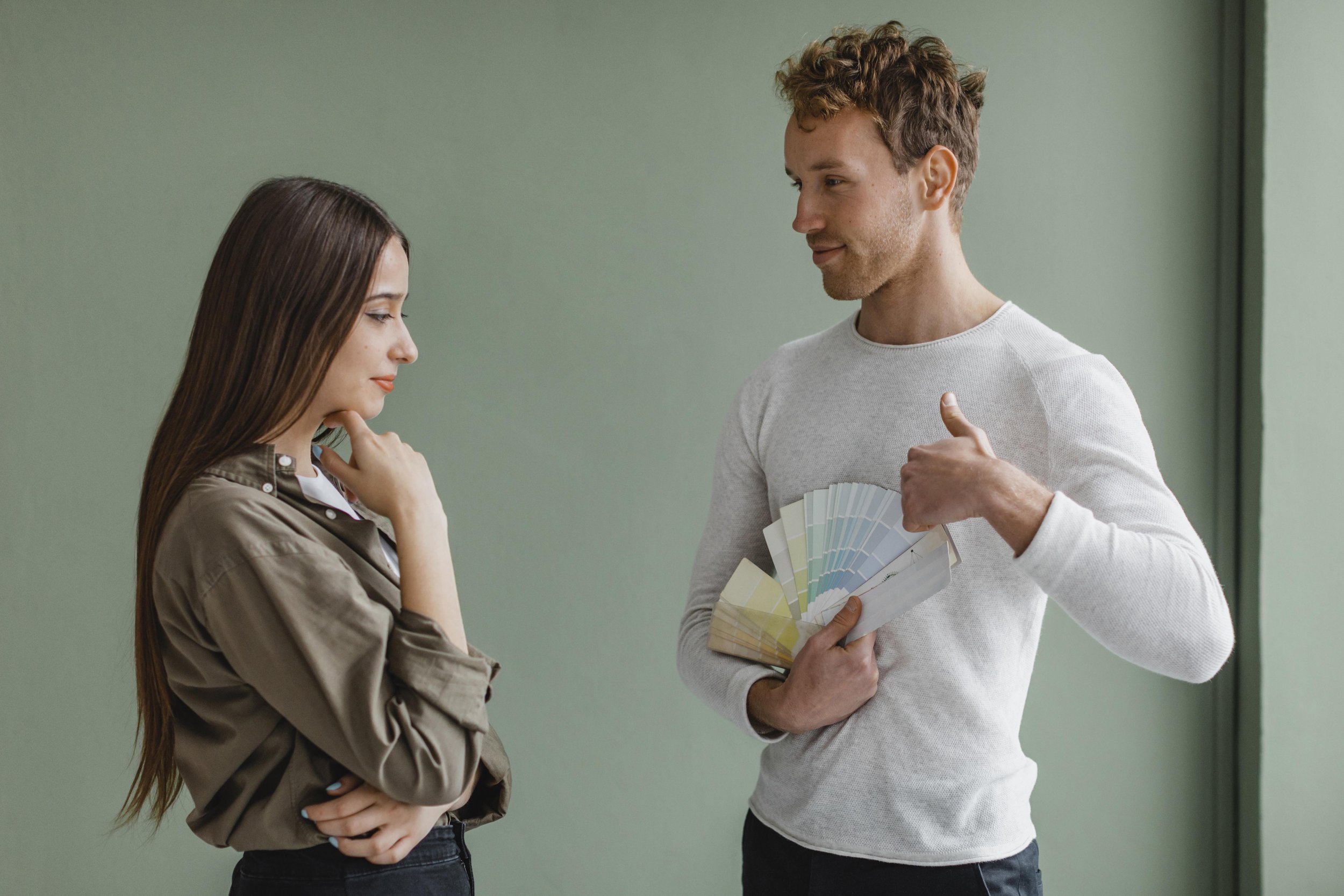 undecided-couple-discussing-redecorating-house-using-paint-palette.jpg