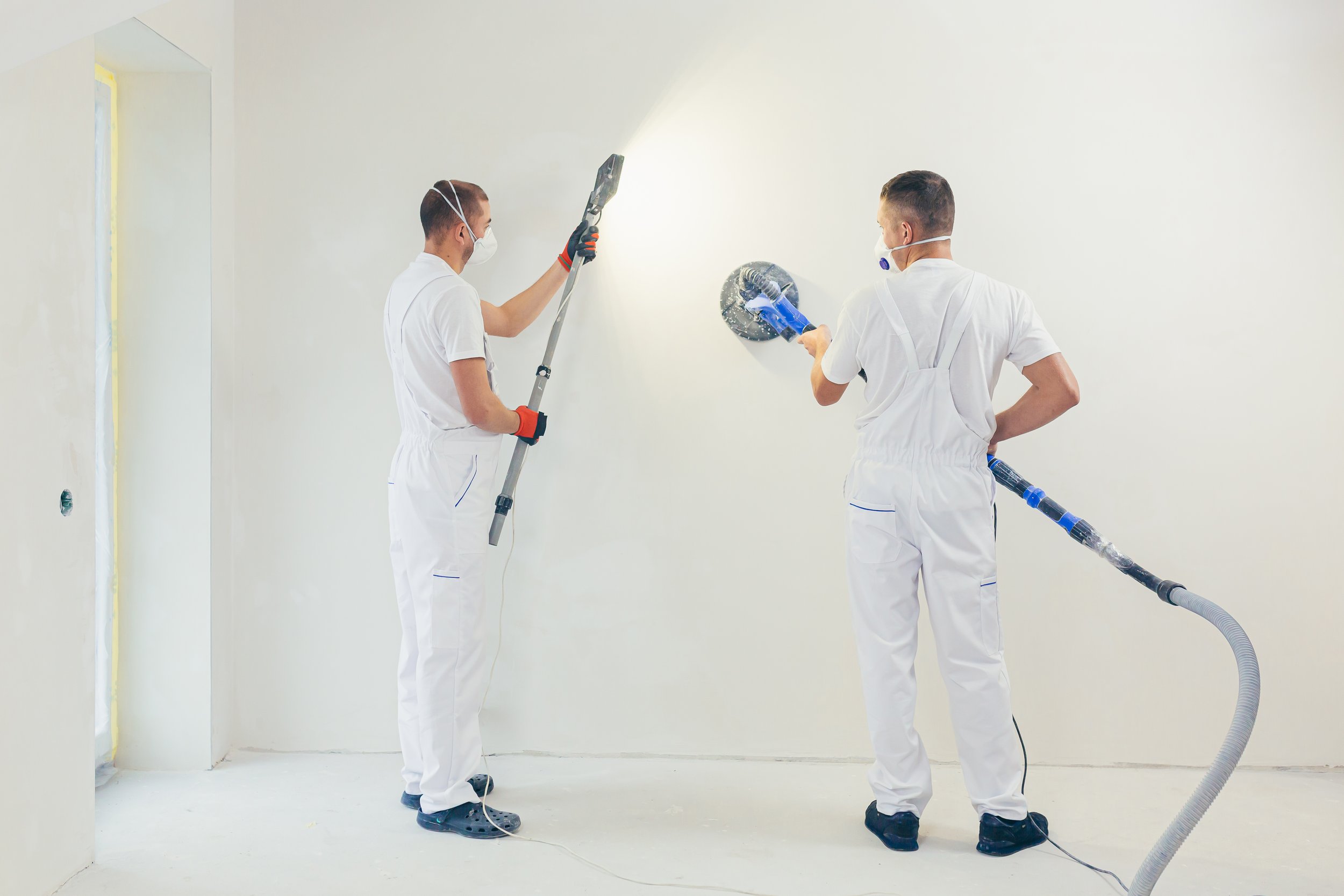 plasterer-smoothes-wall-surface-with-wall-machine-with-sandpaper.jpg