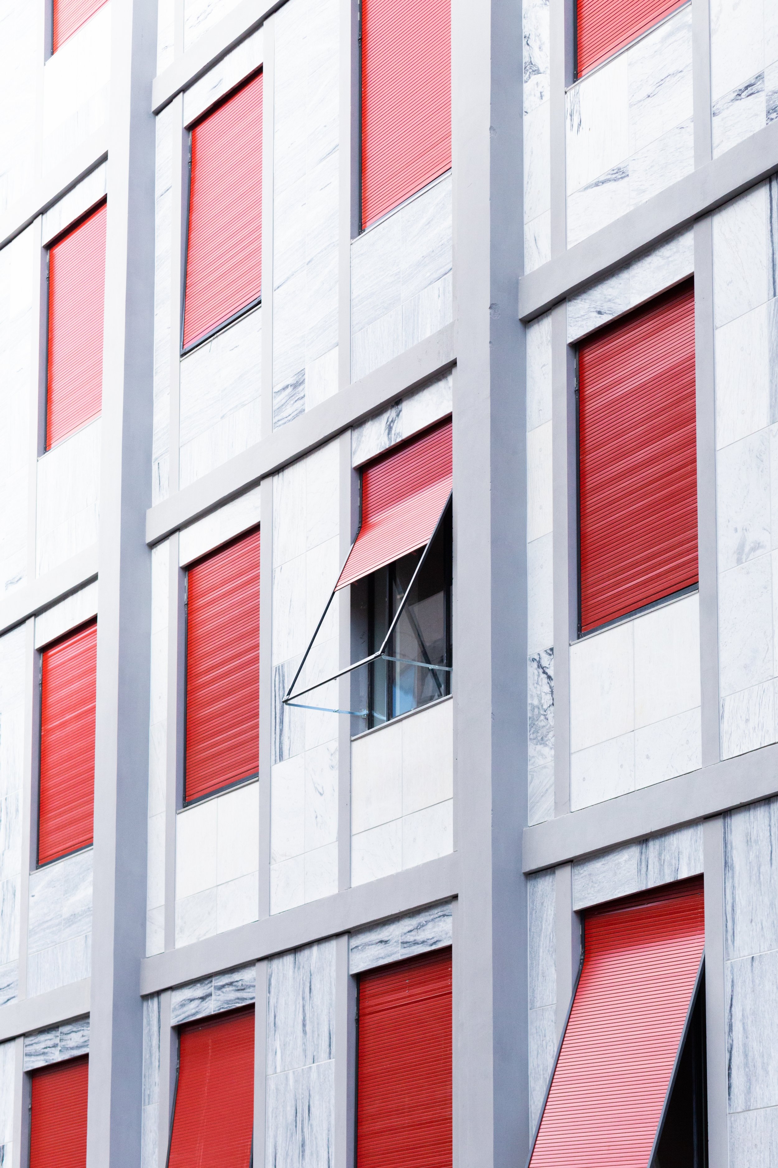 vertical-white-building-with-windows-with-red-blinds.jpg