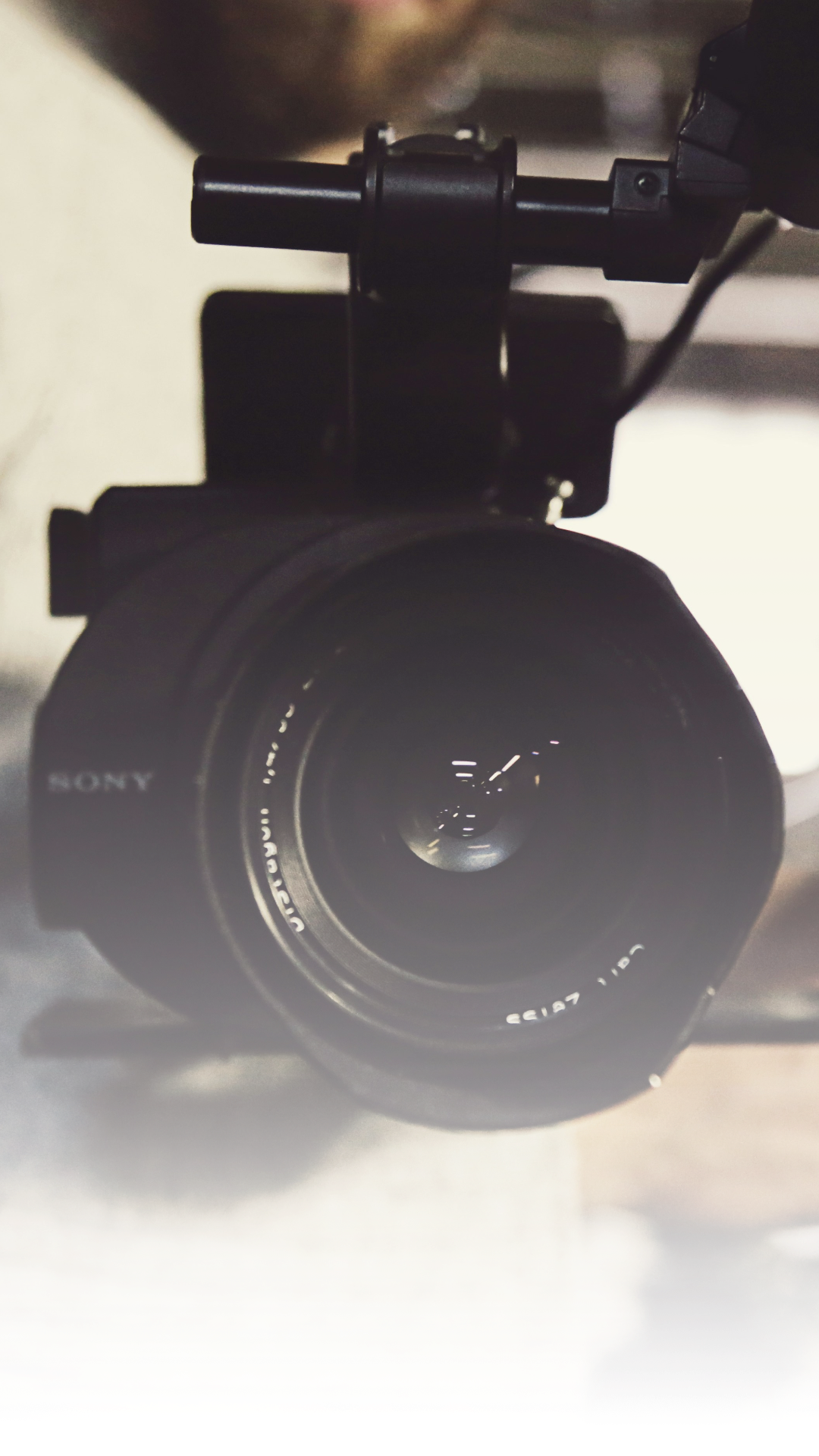 Close-up of a Sony mirrorless camera with a wide lens, mounted on a camera rig or stabilizer.