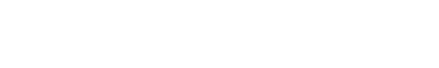 An open book resting on a wooden table illuminated by warm sunlight with a pen beside it.