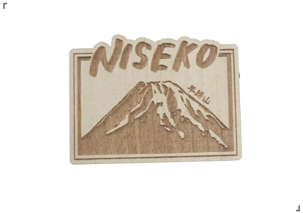 Wooden sign with mountain illustration, the word "NISEKO" at the top, and Japanese characters on the side.