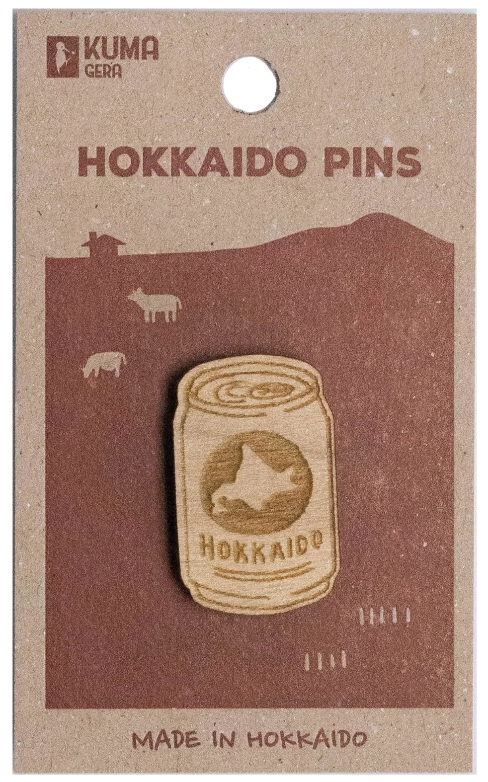 Wooden pin of beer with Hokkaido map, on a cardboard backing labeled Hokkaido pins, made in Hokkaido, with mountain and animal icons and the Kumaga logo at the top.
