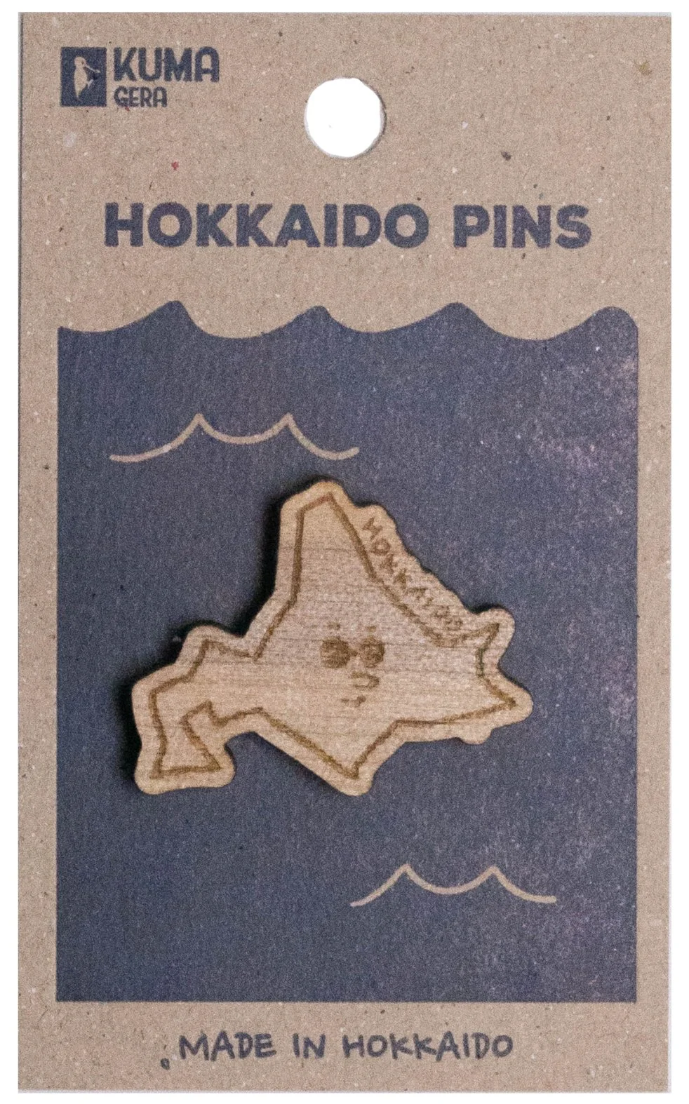 Hokkaido pins shaped like the island of Hokkaido, Japan, on packaging with the title 'Hokkaido Pins' and 'Made in Hokkaido' at the bottom.