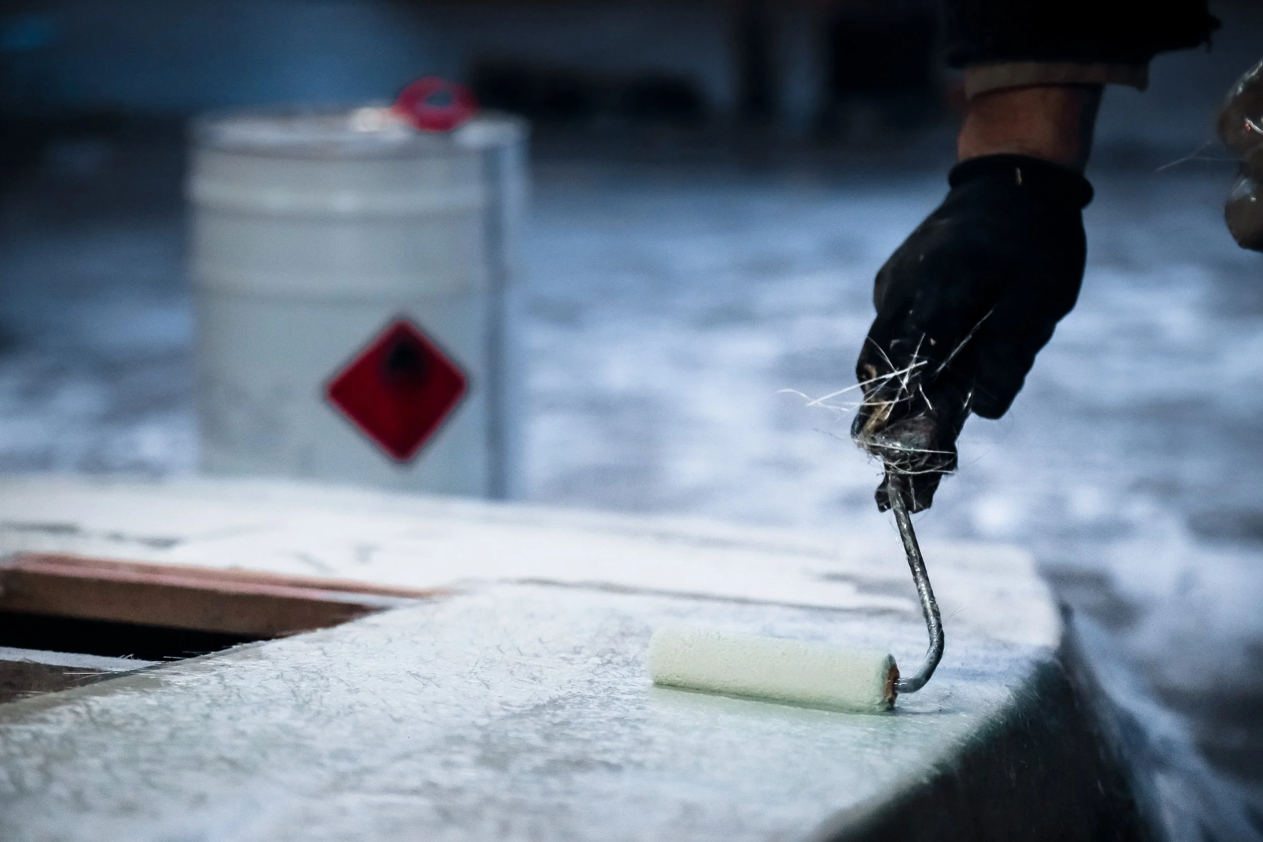 person rolling resin onto fiberglass