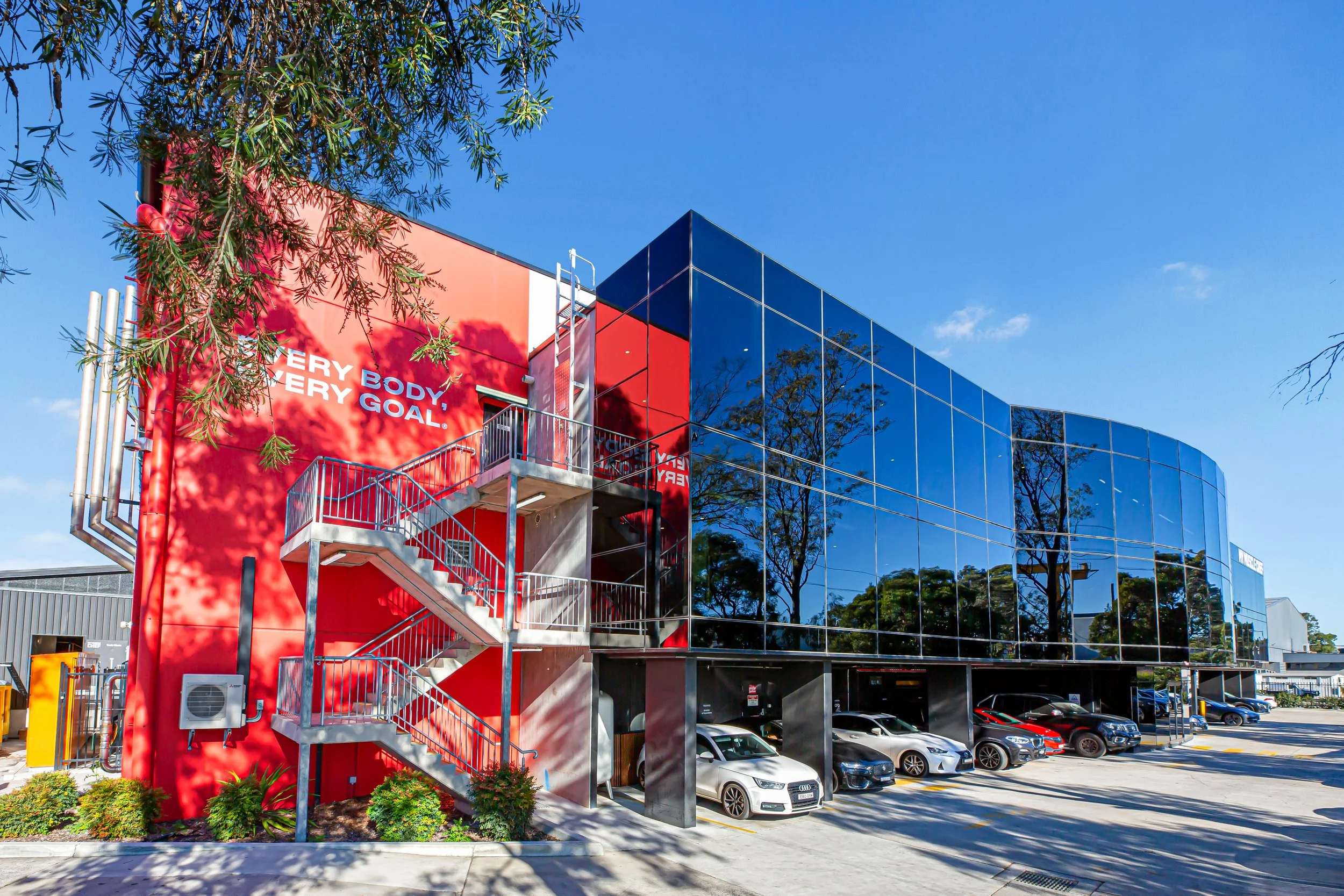 Red & blue corporate office building underneath blue sky