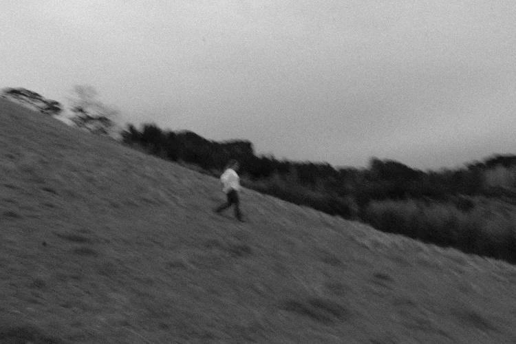 Rosie walking on a steep grassy hillside