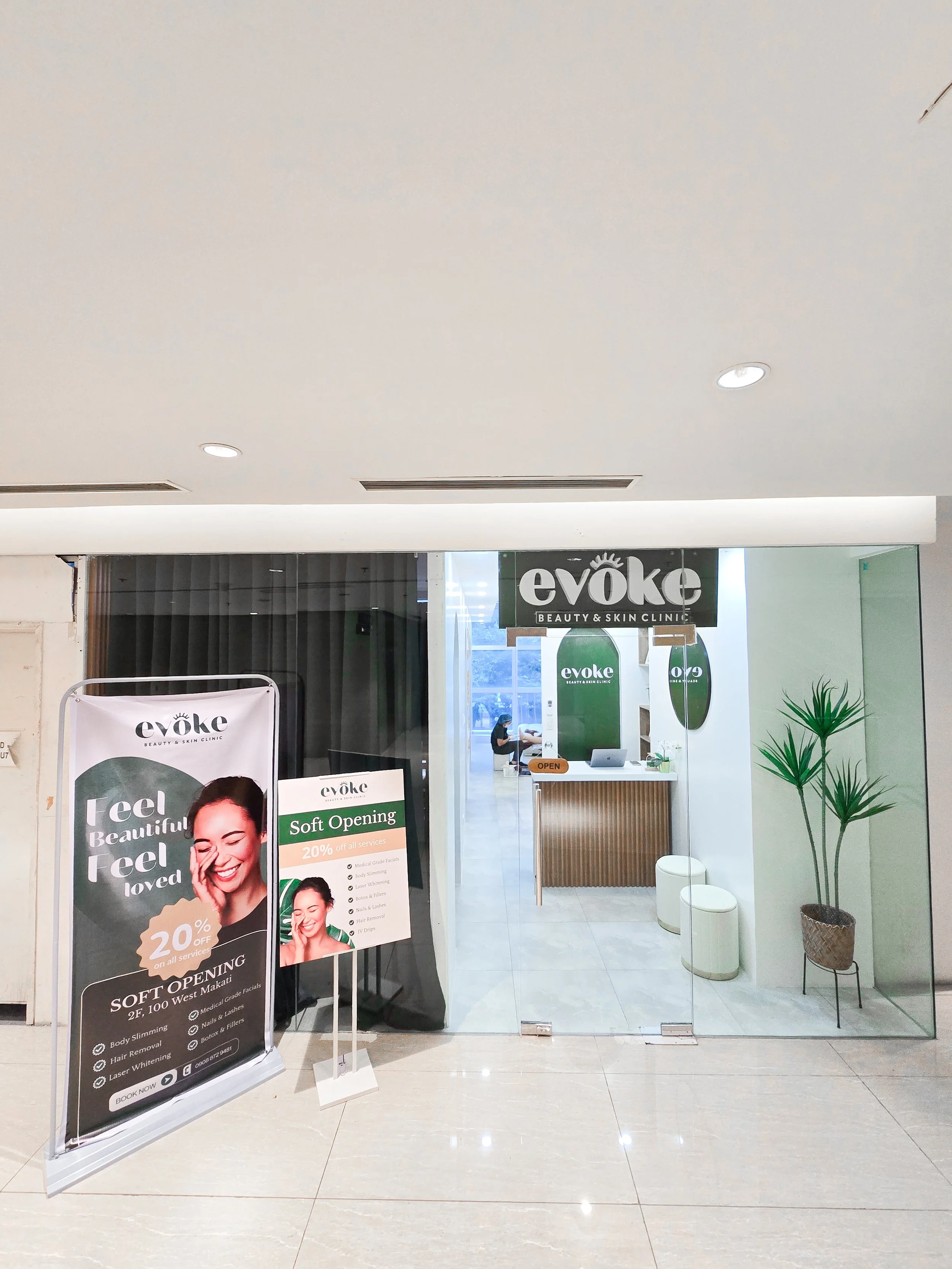 Entrance to Evoke Beauty & Skin Clinic with promotional signs and potted plants